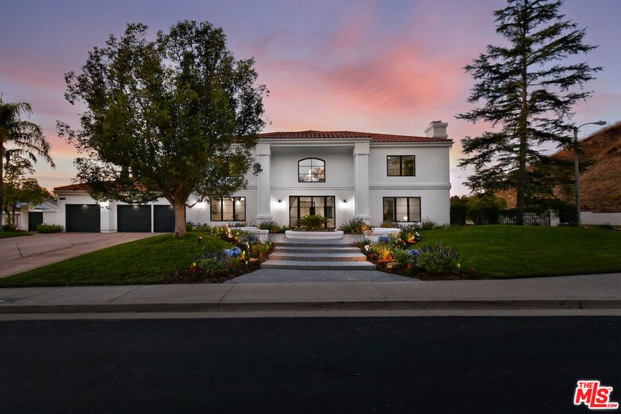 This spectacular, fully remodeled home is located within the prestigious 24-hour guard-gated Mountain View Estates in prime Calabasas. Set on an impressive 17,000 sq ft corner lot, this 5-bedroom, 4.5-bath residence is a true design-forward showplace. A striking metal and glass entry door opens to a dramatic staircase, wide-plank hardwood floors, and new Marvin windows that flood the home with natural light. The reimagined chef's kitchen is the heart of the home, outfitted with top-tier appliances including dual dishwashers, a walk-in pantry, marble countertops, and a built-in serving hub with ice maker and beverage fridge. A pass-through window connects to the expansive outdoor entertaining area. The generous family room, finished with a Venetian plaster fireplace and fully retractable doors, flows seamlessly to the covered patio and backyard beyond. Formal living and dining spaces offer scale and sophistication while remaining functional for modern living. Upstairs, the primary suite is a luxurious retreat featuring a fireplace, sitting area, spa-like bath with glass-enclosed shower, freestanding soaking tub, and a high-end electric toilet. Three additional upstairs bedrooms are spacious and well-appointed. A private office, large utility room, and 3-car garage add to the home's thoughtful layout. The resort-style backyard is designed for year-round enjoyment, complete with a redesigned pool and spa with Baja shelf, built-in BBQ, generous grassy areas, and multiple zones for lounging and entertaining. This is a rare opportunity to own a turnkey property that checks every box, style, function, and setting.