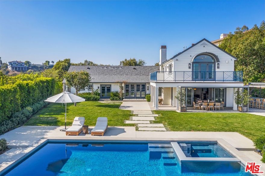 Privately secured behind a gated motor court entry and perched on 1.5+ acres atop one of Bel Air's most coveted streets, this serene haven offers sweeping views of downtown, ridge tops, canyons across to the Pacific Ocean. Completed in 2016, The Himes Miller Group reinterpreted this traditional Hampton-style residence with a progressive approach. The main level presents European hand-scraped white oak floors, a private study, formal sitting area, and 3 ensuite bedrooms. Top level primary quarters features wrap-around terrace with unobstructed mountaintop and ocean vistas, and a fully equipped gym and yoga studio for a focus on health, fitness and recovery. An open kitchen couples with the warm and cozy main entertainment room exhibiting reclaimed wood beams and indoor/outdoor fireplace. Abundant flat grassy land, outdoor bar, sunken fire pit, drop-edge pool and jacuzzi with ozone water system, horseshoe court, gardens & fruit trees. A Custom design to reflect comfortable luxury.