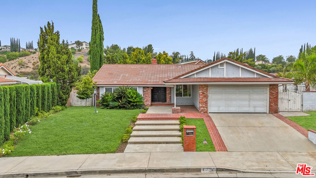 Absolutely stunning and completely remodeled, this single-story home is nestled in the peaceful and highly desirable hills of Porter Ranch. Featuring 3 spacious bedrooms and 4 beautifully updated bathrooms, this residence boasts top-quality upgrades designed to elevate everyday living. From the moment you arrive, you're greeted by a well-manicured front yard with a charming brick walkway that leads into an open-concept interior filled with natural light. The gourmet kitchen is a chef's dream with granite countertops, custom cabinetry, and brand-new stainless steel appliances. The reimagined primary suite offers a tranquil retreat complete with a luxurious new bathroom and oversized air tub. Step outside to your own private resort-style backyardfeaturing a fully remodeled pool and spa, lush grassy play area, and a spacious patio perfect for entertaining. To complete this outdoor paradise, enjoy the convenience of a private outdoor bathroom and shower, ideal for guests or rinsing off after a refreshing swim. This exceptional home blends modern upgrades, thoughtful design, and ultimate outdoor living in one of Porter Ranch's most sought-after neighborhoods.