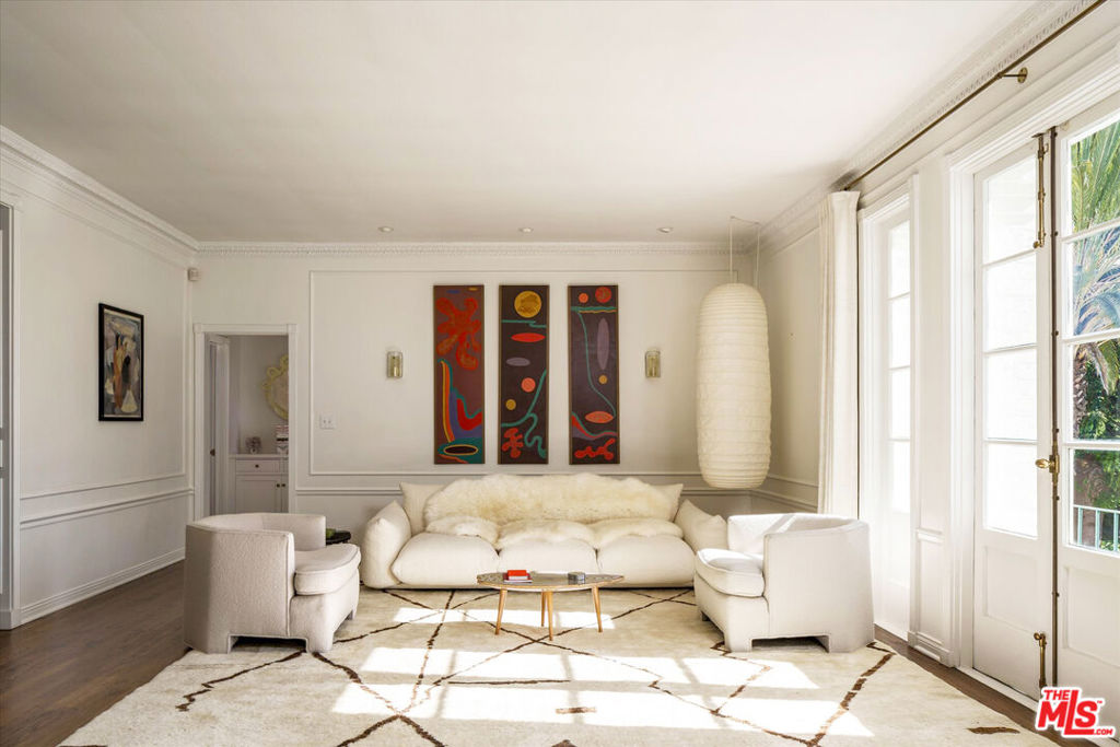 Located in the iconic Colonial House--one of West Hollywood's most storied and desirable buildings--this unit presents a rare opportunity to own a turnkey residence in this Mills Act-designated landmark. This exceptional 3-bedroom, 3-bath unit has been meticulously restored, seamlessly blending historic authenticity with contemporary luxury. Built in 1930 by renowned architect Leland Bryant (architect of the Sunset Tower Hotel) on a coveted block just below the Sunset Strip, the Colonial House has long attracted Hollywood luminaries such as Bette Davis, Cary Grant, and Clark Gable, and continues to embody timeless glamour and sophistication.Thoughtfully renovated to honor its architectural heritage, the home beautifully pairs original 1930s detailing with refined modern finishes. Voluminous and filled with natural light, the space boasts high ceilings, hardwood floors, intricate crown moldings, and handcrafted wood trim. The grand living room is anchored by original French windows, framing ever-changing daylight, and opens to a charming Juliet balcony overlooking the pool area and recently upgraded patio. An elegant fireplace with a carved stone mantel adds further refinement to the space.The formal dining room makes a striking impression with its wallpapered ceiling, designer lighting, and original period windows. A fully reimagined kitchen offers marble countertops, custom cabinetry, premium appliances, and a delightful pointed-arch dining nook. The spacious primary suite includes a walk-through closet with custom cabinetry and a luxurious marble-appointed ensuite bath. The generous second suite features floor-to-ceiling built-in bookshelves, a walk-in closet, and an ensuite renovated bathroom. An intimate third guest room, distinguished by an arched doorway and tasteful designer wallpaper, adds additional charm and flexibility, as does the unit's 3rd bath, with elegant tilework and wallpaper.The unit also features in-unit laundry and a recently updated HVAC system. Residents of Colonial House enjoy premium amenities, including a doorman, security, pool, expansive grassy yard, elegant lobbies, library, secure garage parking, guest parking, and landscaped gardens--all moments from West Hollywood's premier restaurants, boutiques, and cultural landmarks. This residence represents a rare convergence of history, design, and luxury within one of Los Angeles' most celebrated architectural treasures.