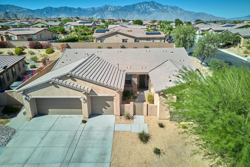 An elegant and highly desirable residence awaits in the peaceful  gated community of The Gallery, perfectly situated on a premier corner lot. This central within community location provides enhanced security and a serene environment, free from the distractions of heavy road noise. With a spacious 2,792 square feet, the thoughtfully designed floor plan includes two luxurious master suites, a full size third bedroom, a dining room, and a generous den or office. The spacious great room, complete with a cozy fireplace, is the heart of the home and an ideal space for entertaining. Culinary enthusiasts will appreciate the chef's kitchen, which features granite slab countertops, Maple Shaker cabinets, stainless steel appliances, and under-cabinet lighting. Quality finishes abound throughout, from the 20x20 floor tile to the custom plantation shutters, creating a cohesive and enjoyable living space. The exterior boasts beautifully low maintenance landscaping, allowing more time for enjoying the desert lifestyle. The expansive 13,000+ square-foot corner lot offers ample space for you and your family to enjoy the beauty and tranquility your back yard has to offer, create your personal desert oasis. Additionally, a full three-car garage provides plenty of room for vehicles, storage, and hobbies. This exceptionally clean and move-in-ready home presents an extraordinary opportunity for refined living within a superb, central community location, all complemented by low HOA fees unheard of in such a well maintained community.