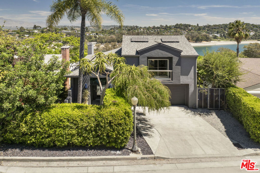 In prime Silver Lake, this radiant, updated Modern commands spectacular panoramic vistas and enjoys rare privacy within the coveted Ivanhoe Elementary boundary. Vaulted ceilings, oversized windows, and sliding doors bring in sunlight and frame striking views of the Reservoir and mountains, opening to decks for morning coffee and al fresco dinners in the glow of moonrise over the hills. Newly refinished hardwood floors with an eco-friendly European finish run throughout the expansive open-plan layout; the stylish kitchen includes stainless appliances and a Carrara marble waterfall island. Three bedrooms include a top-level primary with a sitting room, private terrace, and luxe bath with incredible sightlines. Multiple Trex decks extend the living space outdoors; the updated yard is a serene setting with ten mature fruit trees and room to add a pool. Amenities include HVAC, owned solar panels, gated access, and garage. You're just blocks from LAMILL, Broome Street, Forage, the Reservoir, and more.