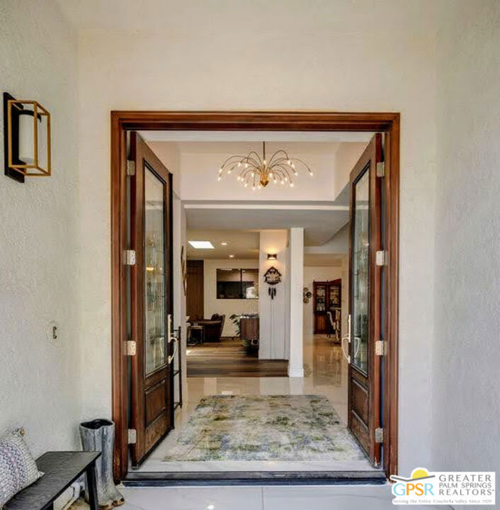 This isn't just a house, it is a space that inspires. Natural light pours in through skylights, dancing across vaulted ceilings and art-worthy walls. The open floor plan flows effortlessly, with thoughtful separation of space that makes entertaining easy and private retreats possible. Three generous living areas set the stage for gatherings big and small, whether it's a weekend full of friends or a quiet night at home. The primary suite has its own private wing, a true retreat with a sitting area (currently an office), a secluded patio, and a spa-like bath. Two additional en-suite bedrooms, one oversized, are perfectly placed for guests. At the heart of the home, a custom bar with wine and beverage fridges meets a TV wall built for movie nights or game-day celebrations. The modern kitchen, with walk-in pantry and abundant storage, keeps the chef part of the party. Most appliances are less than two years old. Two custom fireplaces, each finished with striking tile, bring both warmth and a touch of artistic drama, while outside a grassy yard welcomes kids and pets. A 10-person swim spa offers year-round relaxation, and close by, you'll find the community pool, spa, tennis, and pickleball courts. Set in a gated community beside the world-famous Sunnylands estate and across from Mission Hills, you're minutes from luxury shopping, favorite everyday stores, and the upcoming Disney Cotino community. With front yard care included in the HOA dues and 60 leased solar panels for energy efficiency, it's as easy to lock-and-leave as it is to stay and savor. Come see for yourself why 12 Santa Clara Drive isn't just a home, it's where your next chapter of elevated desert living begins.