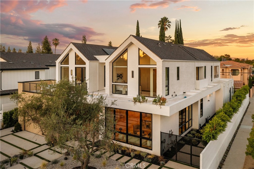 Introducing The Enfield, a newly built Scandinavian-inspired estate tucked within one of Encino’s most sought-after neighborhoods. This modern showpiece spans approximately 5,200 sq ft and features 5 bedrooms, 5.5 baths, plus a private 1-bedroom ADU with its own entrance.
The interiors impress at every turn: soaring ceilings, a dramatic spiral staircase, and wide-plank French oak flooring set the stage. At the heart of the home lies a chef’s kitchen appointed with an oval Quartzite island, Quartzite countertops, Thermador appliances, and custom cabinetry that flows seamlessly into the backyard. The living room is anchored by a marble fireplace, while a private office provides an ideal workspace or additional bedroom. Upstairs, the primary suite offers dual walk-in closets, a stone fireplace, a spa-inspired bath, and a 300-square-foot balcony overlooking the grounds.
Perfect for grand entertaining or intimate gatherings, the backyard is a true retreat with a smart-controlled pool and spa, built-in BBQ, and manicured landscaping. Additional amenities include solar panels, whole-home surround sound, EV charging stations, and a fully integrated security system.
Now available for lease and also offered for sale, The Enfield is ideally suited for discerning families, entertainers, or influencers seeking modern luxury in a prime location between Hollywood and Beverly Hills. Ideally positioned near places of worship, the esteemed Crespi Carmelite School, and Encino’s finest family-oriented amenities, this residence offers both convenience and prestige. An expansive and elegant retreat, it presents a rare opportunity to experience the best of Encino living.