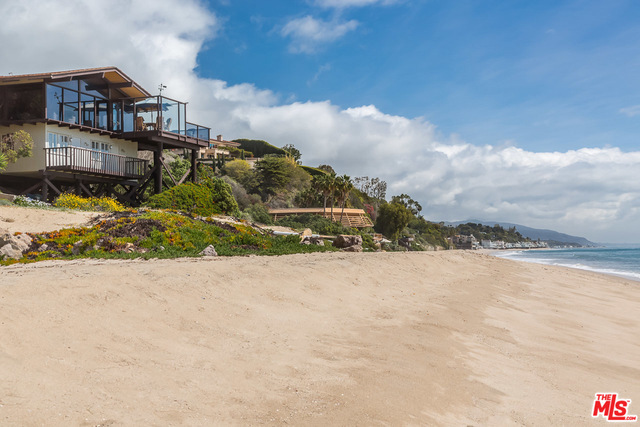 Extremely rare offering on 1.6 acres stretching from the PCH to the prized sands of Escondido beach, offering 57 ft of prime ocean frontage. Existing two story beach house features floor to ceiling glass, two enormous decks and truly incredible remodeling potential. Even better, the home enjoys rare, grandfathered-in, reduced setbacks that give it advantageous beach positioning and total isolation from other eastern side structures. Offering one of the best vantage points along the beach with an outstanding level of seclusion. Gated lot's upper tier offers a huge flat pad is ripe for development. 27724 PCH is without question one of the most exceptional lots in Malibu offering incomparable potential and the opportunity to create a spectacular resort-like ocean estate.