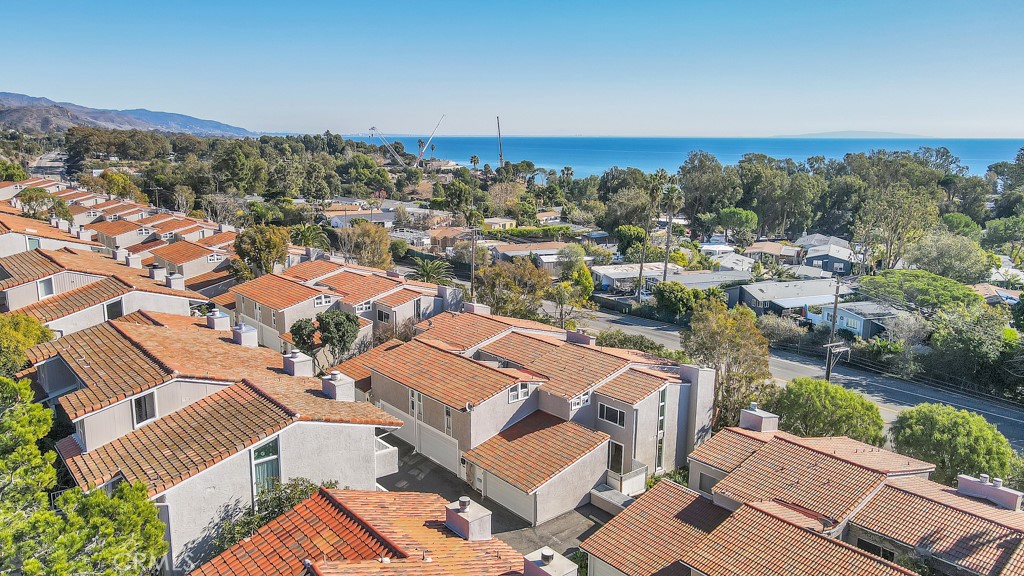 Updated Malibu Villas townhome just off PCH across from Paradise Cove. This 2 bedroom and 2.5 bath has been updated with fresh paint throughout as well as newer Carrara marble kitchen counters, custom cabinets, and stainless appliances. First floor has a split level open floor plan with custom bookshelf, decorative fireplace, half bath and two patios. Both upstairs bedrooms have beautiful vaulted ceilings with updated en suite bathrooms that feature oversize spa showers. Home features built in wall AC (which is rare for this complex), front and back patios, and an upstairs balcony. Extra storage in the attached 2 car garage which has direct home access and includes washer/dryer. Complex offers pool, spa, and clubhouse. Water and trash included.