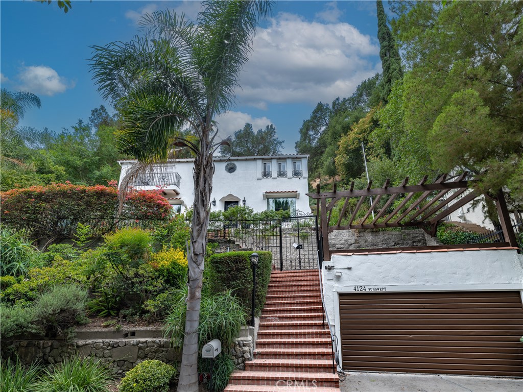 Classic Spanish Colonial Revival with Modern Sophistication. Tucked away in the quiet hills of Studio City south of Ventura Boulevard, this beautifully preserved 1929-built Spanish Colonial Revival home blends timeless architecture with tasteful modern updates. Featuring 3 bedrooms and 3 bathrooms, the home is rich in period character showcasing white stucco walls, terracotta roof tiles, arched doorways, and elegant wrought-iron details. Inside, hand-troweled plaster walls and dark wood floors set a warm, authentic tone. Sunlight pours through oversized windows and French doors, enhancing the home’s natural charm and creating an inviting ambiance throughout. The remodeled kitchen is both stylish and functional, with white shaker cabinetry, granite countertops, stainless steel appliances, and a statement mosaic tile backsplash. A cozy breakfast nook and formal dining room provide perfect spaces for everyday living and entertaining. Upstairs, the serene primary suite offers vaulted ceilings, dual closets, and a Juliet balcony ideal for letting in fresh air and light. The ensuite bath evokes a spa-like atmosphere with a freestanding clawfoot tub beneath a picture window, a marble double vanity, and classic white subway tile. Additional highlights include vintage-inspired light fixtures, arched transitions, a wrought-iron staircase, and spacious secondary bedrooms. Outside, thoughtfully landscaped grounds offer multiple patios and quiet corners for lounging, dining, or simply enjoying the peaceful surroundings. A true gem that captures the romance of historic Spanish architecture while offering modern comfort, this home is a rare opportunity in one of Studio City’s most desirable neighborhoods.