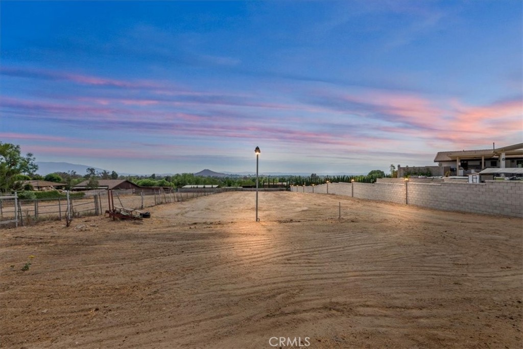 Spectacular EQUESTRIAN Property with STUNNING SUNSET Views & Prime location of Norco! Premier horse property with tons of land and close to riding trails and the Santa Ana Riverbed where you will find 100's of miles of trails. Situated on Crestview Drive with unobstructed sunset, hills, and mountain views! Just steps from Pikes Peak Park, Ingalls Equestrian Center, Pumpkin Rock hiking trails, and Hidden Valley Golf Course. Prime Equestrian living, and unbeatable convenience. This expansive single-story home features 4 bedrooms and 2 bathrooms with a spacious, open floor plan, ideal for entertaining. The family room boasts beamed ceilings and a classic brick fireplace, creating a cozy yet grand atmosphere. The kitchen overlooks the family room and the backyard—perfect for taking in breathtaking sunset views while cooking dinner. Two of the bedrooms are oversized at approximately 15x15, offering comfort and flexibility rarely found. The primary suite includes a private ensuite bath with dual sinks and has the potential to add a sliding glass door to take full advantage of the stunning sunset views right from your bedroom. Upgrades include replacing plumbing with copper pipes and a newer AC unit, ensuring comfort and reliability. BRAND NEW Block wall with beautiful lighting on each post. The Outdoor area is a massive lot and ready for all your animals and equestrian dreams. The property features a 4-horse block barn that stays much cooler in the summer heat. Tack room and a room upstairs above the barn allows for extra storage. Electrical throughout the grounds for arena lighting, a hot walker, and other equestrian needs, and ample room for a round pen, training arena, additional stalls, or even a custom equestrian sanctuary. An extra-tall 10x12 Tuff Shed with double doors provides additional storage, and a 10x12 steel workshop built to withstand 200 mph winds adds even more functionality. Imagine adding an infinity pool overlooking your equestrian setup, creating a one-of-a-kind ranch retreat. This prime location allows you to walk to everything Norco has to offer—rodeos, horse shows, trails, parades, fairs and more. Bring your horses, cows, goats, pigs, sheep, or chickens—Norco is the ultimate destination for animal lovers and equestrian enthusiasts. With a little vision and personal touch, this property could easily become your forever dream home. Don’t miss your chance to own this rare view lot and horse property gem on Crestview!