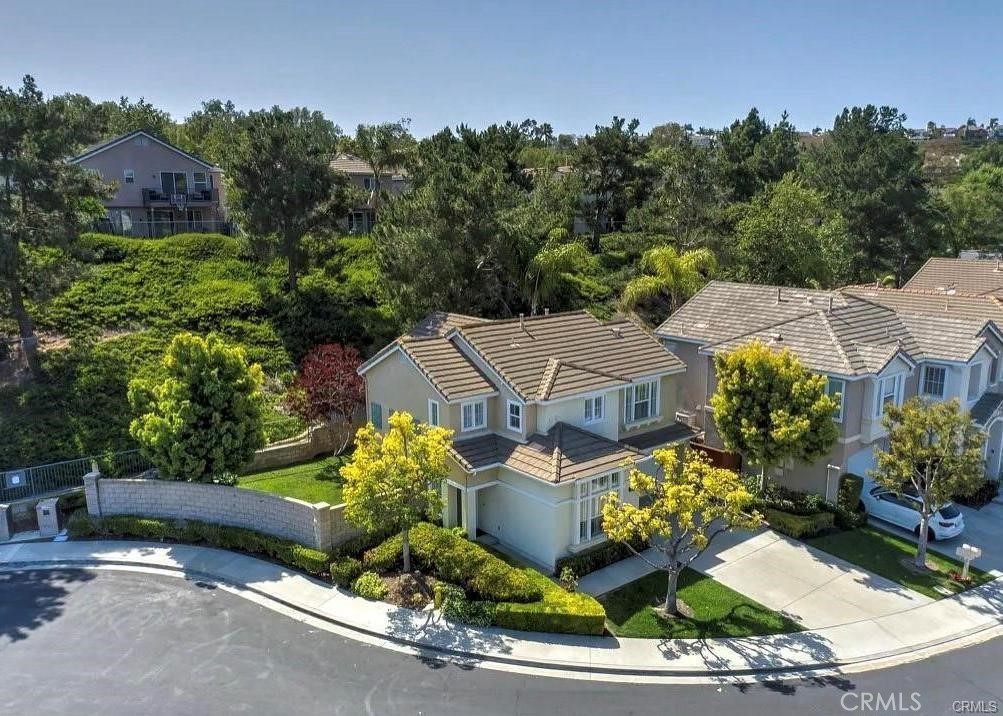 Ideally located on a premium pie-shaped corner lot at the end of a cul-de-sac, this beautiful home offers the best of Aliso Viejo living. Just minutes from Town Center, top-rated schools, parks, restaurants, and entertainment, this home is perfect for those who value comfort, style, and convenience. Step inside to discover upgrades throughout, including a newer kitchen with newer appliances, abundant cabinetry, recessed lighting, and a walk-in pantry. The open living area features laminate wood flooring, plantation shutters, and a custom stacked-stone fireplace that adds warmth and charm. The desirable main-floor bedroom with an adjacent full bath offers the flexibility of a guest room, home office, or private retreat. Upstairs, the spacious primary suite boasts soaring ceilings, a cooling ceiling fan, a walk-in wardrobe, and a remodeled ensuite bath with dual vanities, updated lighting, and modern fixtures. A large bonus room upstairs offers exceptional versatility, use it as a fourth bedroom (with closet), home gym, office, craft room, or playroom. An additional upstairs bedroom enjoys its own private bath, perfect for family or guests. The nicely sized backyard is perfect for entertaining with a cozy gas fire pit and Arizona flagstone patio with low-maintenance aluminum patio cover. It’s ideal for al fresco dining, summer gatherings, or simply relaxing in your private outdoor oasis. Enjoy direct access to hiking and biking trails that lead all the way to the ocean just 15 minutes to the beach! Plus, enjoy fireworks on the 4th of July near Town Center, and quick access to the 73 Toll Road. This is Aliso Viejo living at its finest don’t miss your chance to make it your home!