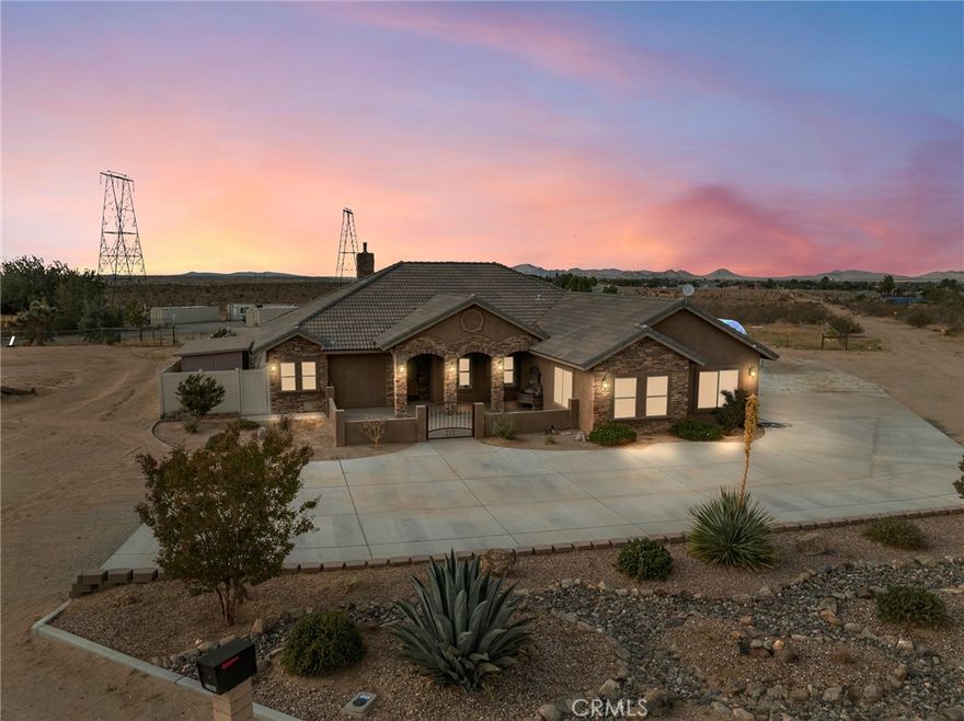 Luxury, Privacy and Stunning Views!  Welcome home to this stunning 3-Bedroom, 3-Bath, 2253 SF Desert retreat.  A true jewel nestled on a sprawling 2.5-acre lot with breathtaking views along with every amenity you could dream of.  This thoughtfully designed home offers DUAL PRIMARY SUITES, each with spa-inspired bathrooms featuring walk-in showers, jetted tubs, and spacious walk-in closets-Ideal for privacy, comfort, or multi-generational living. At the heart of the home is a chef's kitchen designed to impress, complete with high end appliances, expansive countertops, and plenty of storage-a true culinary haven for entertaining or everyday living. The elegance continues throughout with tile flooring, plantation shutters, crown molding with ambient lighting, ceiling fans in every room, and French doors that blend indoor comfort with outdoor living. Step outside to your private resort-style backyard, where luxury and tranquility meet. Custom Pool and Spa with cascading waterfalls, fire bowls, and an automatic pool cover. Outdoor kitchen/BBQ for year-round entertaining, sunset dinners, or enjoying a quiet morning coffee. Pergola-covered patio, putting green for the golf enthusiast, vinyl privacy fencing along with desert friendly landscaping. Gated front courtyard with water feature and beautiful decorative stack stone enhances the entry. Additional features include oversized 2-car garage, RV pad, Security cameras/alarm system.  Per County of San Bernardino, up to two (2) additional ADU units can be built per 2.5 acres, ideal for guest quarters or income potential.  Whether you are seeking a peaceful desert sanctuary, a forever home with room to grow, or an entertainer's paradise, this exceptional property checks all the boxes.  Come experience the lifestyle you've been dreaming of.