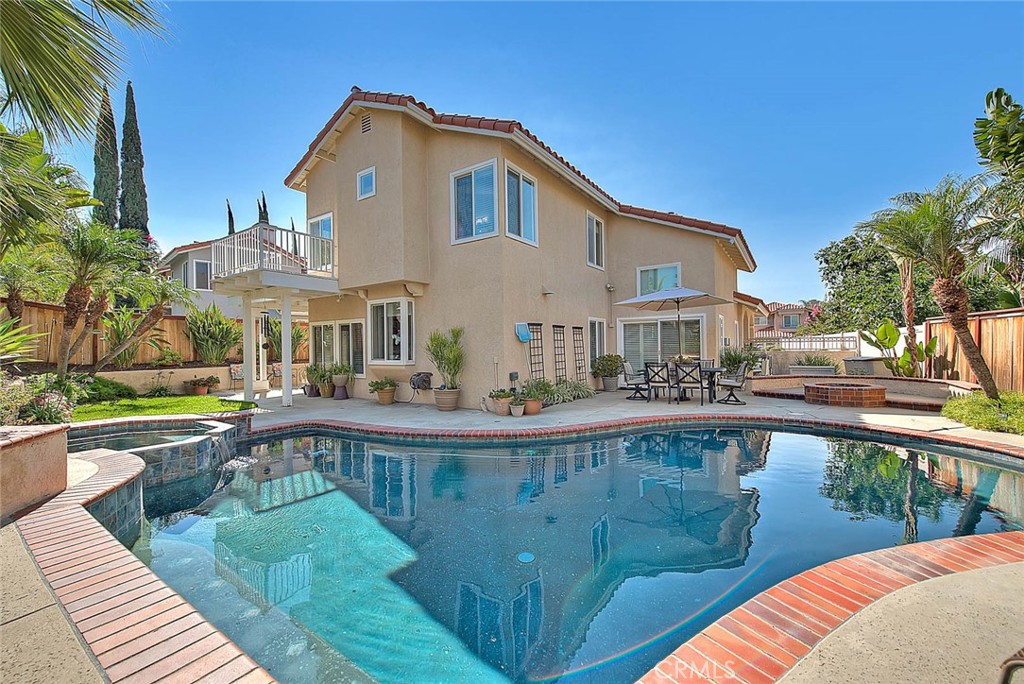 DAZZLING 4 bedroom/3 bath residence, ELEGANTLY upgraded throughout in contemporary design style. Backyard is done with a tropical theme and boasts salt water swimming pool & spa, all in a lushly landscaped setting. Paver design for the front courtyard entry boasts great curb appeal. Soaring ceilings greet you as you enter the formal living room. Unique stair railing done with wrought iron has a modern aesthetic, a fabulous focal point & accent to this room. The formal dining room (situated between the living room & kitchen) is nicely sized and allows for a larger group dining space. DRAMATIC gourmet kitchen features cherry wood cabinetry (done in dark chocolate stain), quartz counters, pull out drawers, custom Murano pendant lighting as well as recessed lighting, stainless appliances including a Thermador stove top & spacious breakfast nook. The nook opens to the family room which enjoys updated fireplace masonry. Convenient downstairs bedroom w/easy access to the 3/4 bathroom. All bathrooms have been beautifully remodeled with new vanities, flooring, re-done showers & fixtures. Elegant primary suite with retreat, spacious walk in closet and private access to large outdoor deck. The lovely primary bathroom showcases a stand alone soaking tub, upgraded flooring, new vanity cabinetry, quartz counters & fixtures. Generously sized bonus room has a fireplace & custom built ins. This room could be used as a 5th bedroom if needed, home office or upstairs recreation room (multiple options). Other notables: Maple flooring downstairs, upgraded tile flooring in kitchen, 3 bathrooms & laundry room, upgraded lighting fixtures, upgraded windows throughout, roof is approximately 8 yrs old, upgraded attic insulation, newer back yard fencing, upgraded window coverings including plantation shutters, roman shades blinds & custom valances. Backyard is designed for outdoor entertaining! Whether enjoying the pool/spa or barbecue & outdoor dining the setting is fantastic! Pride of ownership is apparent throughout this property, a truly GORGEOUS home that will impress all that tour.