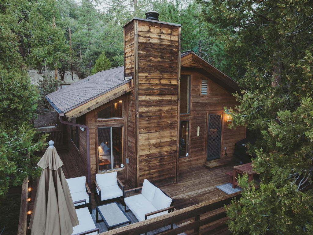 Discover your perfect mountain retreat in the heart of Idyllwild! This adorable cabin is filled with character and charm, offering the ideal blend of rustic comfort and modern upgrades. Relax and take in the incredible views from your brand-new-deck, perfect for morning coffee, or evening sunsets, or entertaining under the stars. Inside, you will be greeted by a large living area with floor to ceiling wood burning brick fireplace, high vaulted souring ceiling, bright and light with several windows for the absolute amazing views. This cozy cabin features 2 bedrooms and a full sized bathroom with newer vanity, a cute and cozy kitchen area, a separate dining area with all new lighting. Recently remodeled with a new outdoor deck, stairs and fencing, surrounded by twinkling lights. Newer water heater, AC was added in 2020 for year round comfort, many upgrades have been done by the sellers. Located just minutes to downtown Idyllwild for quaint boutiques and restaurants. There is also a downstairs basement under the cabin that can be converted to another living space. SOLD TURNKEY FURNISHED. Come see this COZY CABIN today. Sellers want this cabin SOLD!