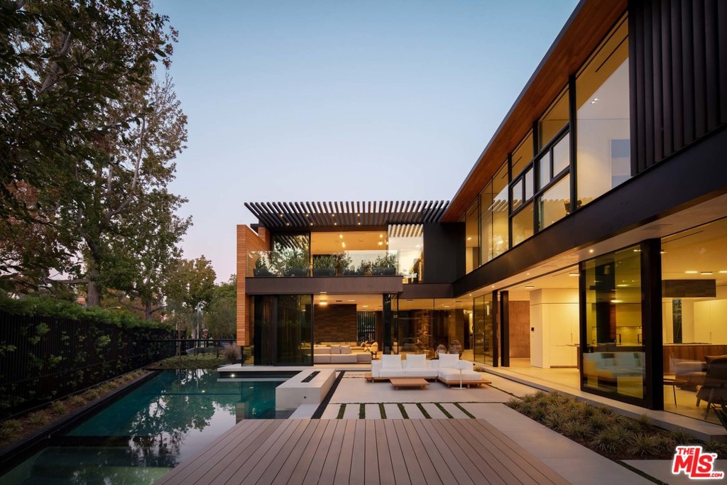Masterfully designed by Tag Front Architects, this extraordinary contemporary-style estate in the heart of Beverly Hills is full of outstanding amenities. Walls of glass allow an abundance of natural sunlight to illuminate the inside, providing an airy feel that seamlessly compliments the indoor/outdoor flow of the estate. The main level features dual living rooms separated by a beautiful marble fireplace, Boffi gourmet kitchen with Gaggenau appliances, formal dining room, office, and an intimate den leading to a world-class pool & backyard space. An elegant master suite, with its own private terrace, steel boiler-fireplace by Antonio Lupi, dual marble vanities, and custom walk-in closets, champions the second floor alongside 4 other expansive suites. A luxurious separate guest house, outfitted in steel and wood elements, runs along the back of the main home to peacefully accommodate friends or family. Additional highlights include a commercial-size theatre, steam room, sauna, fitness center, 8-car garage gallery, gated driveway, and 16-unique A/C zones. This estate offers functionality and easy-living, while boasting the ultimate museum-quality aesthetic and materials.