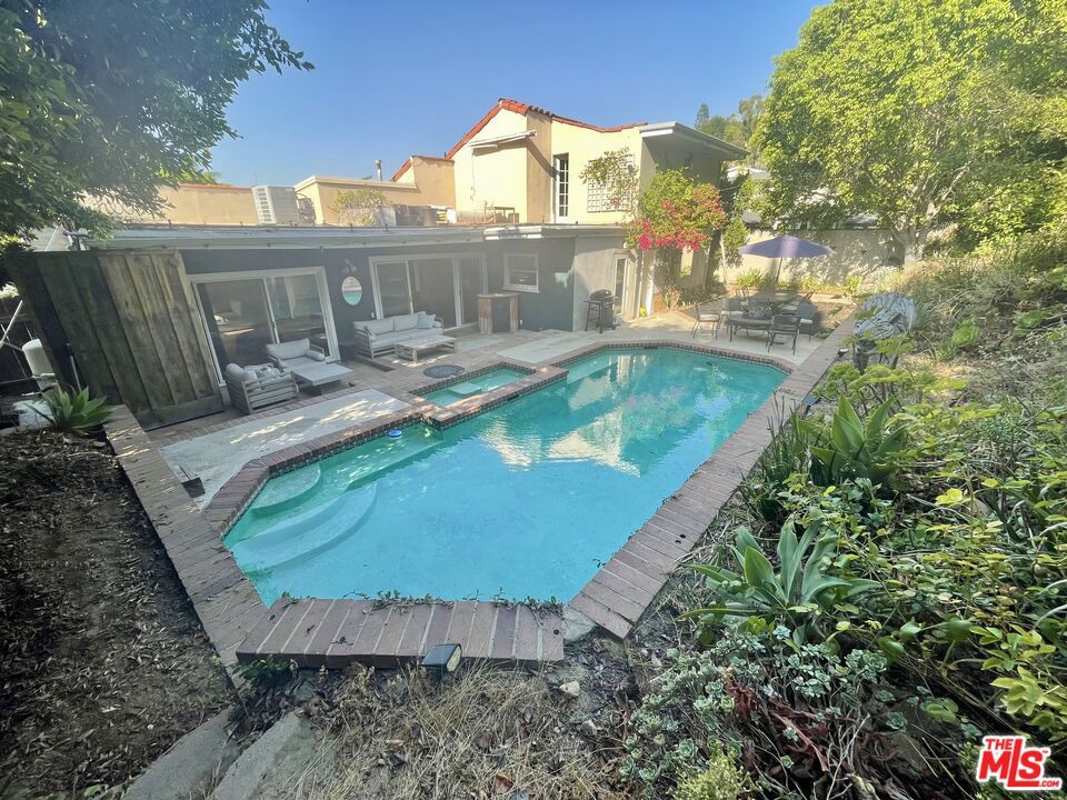 Discover your own private sanctuary nestled south of Ventura Boulevard in Studio City's most coveted celebrity neighborhood, The Donas. This stunning retreat offers unparalleled privacy and luxury in one of LA's most exclusive enclaves, where A-list neighbors and multimillion-dollar estates define the landscape. With comparable homes in this prestigious pocket commanding $13,500+ per month, this represents exceptional value in Hollywood's hidden gem, just minutes from Universal Studios and the trendy dining scene along Ventura Boulevard. This spectacular three-bedroom, two-bathroom home showcases sophisticated design with an open-concept layout perfect for entertaining. The gourmet kitchen features professional-grade Thermador appliances including griddle and convection oven, complemented by a brand-new LG refrigerator and rolling chef's block for the ultimate culinary experience. Polished cement and bamboo flooring flow seamlessly throughout the main level, anchored by a cozy gas fireplace that creates perfect ambiance. Two beautifully appointed bedrooms on the main floor provide comfort and style, while the oversized upstairs master suite serves as a true sanctuary with walk-in closet and private rooftop deck offering breathtaking mountain and city light views. The resort-style outdoor living experience rivals any five-star destination, featuring a heated pool and spa surrounded by lush gardens. Meandering garden paths lead to spectacular viewpoints where you can take in stunning sunsets. This peaceful and private retreat sits in whisper-quiet surroundings with a nature-inspired setting, yet remains perfectly positioned within the coveted Carpenter School District, recognized among LA's finest schools. Fully furnished this home allows you to simply arrive with your toothbrush and start living the dream. The oversized two-car garage provides abundant storage along with driveway and street parking for guests. For additional flexibility, an optional private one-bedroom, one-bathroom guest studio with separate entrance is available for an additional $1,500 monthly, perfect for visitors, office space, etc. This property is available for short-term lease with longer-term arrangements negotiable, this is your opportunity to elevate your lifestyle in Hollywood's most exclusive neighborhood where privacy meets prestige. Don't miss this rare chance to experience living in The Donas.