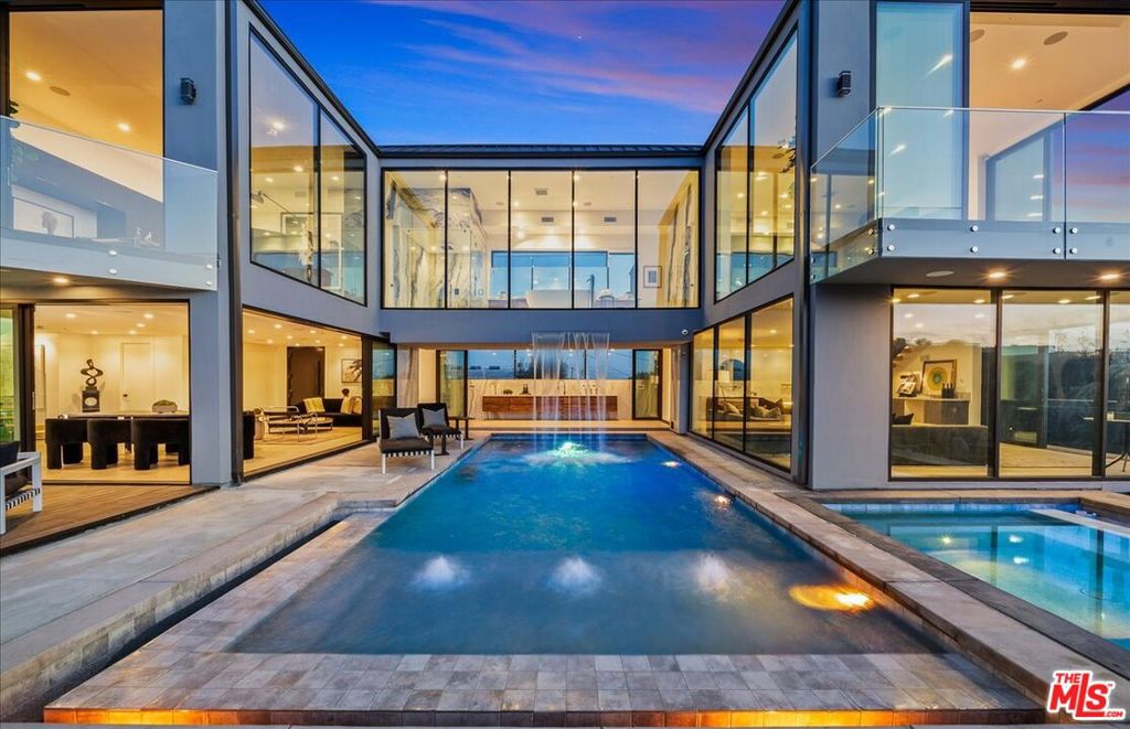 Welcome to "The Hollywood Observatory," a striking architectural retreat tucked away on an exclusive private street just above Sunset Plaza. With commanding jetliner views from nearly every room stretching from Century City to the Pacific Ocean, this modern masterpiece offers one of the most compelling values currently available in the Hollywood Hills. Floor-to-ceiling glass walls blur the line between interior and exterior, creating a seamless indoor-outdoor flow ideal for both intimate living and grand-scale entertaining. At the center of the estate, a dramatic resort-style pool and spa are framed by a Niagara Falls-inspired waterfall, a showstopping fire pit, outdoor kitchen, bar, and expansive dining area. A dedicated wellness space adds a tranquil dimension, perfect for yoga, meditation, and cold plunges. Upstairs, the primary suite stuns with panoramic views of Downtown LA, the ocean, and the city skyline, and is complete with a luxurious spa-style bathroom and an inspiring home office. With a consistent track record of over $600,000 in verifiable annual short-term rental income, this property offers exceptional investment upside in addition to its lifestyle appeal. Just minutes from the Sunset Strip and West Hollywood's best restaurants, boutiques, and nightlife, this gated hideaway offers unmatched privacy and convenience. With the added potential of turning Haslam Terrace into a privately gated street, this is a rare opportunity to own a true design-forward sanctuary at a price point that makes it one of the best deals in the entire Hollywood Hills. Creative financing available where the future buyer may take over existing debt at a 2.75% interest rate on $2.75M in debt with the balance of the purchase price to be provided as buyer equity. A rare opportunity for an owner user, 1031 exchange investor, or conventional investor to own one of the city's most compelling view properties with unmatched income potential, all while at one of the best prices for an architectural masterpiece home in the Sunset Strip.