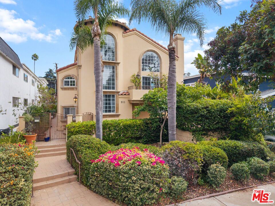 Flooded with natural light from soaring floor-to-ceiling windows, this striking tri-level townhome offers the perfect blend of style, comfort, and functionality. A private front-facing residence with its own yard, the home evokes a Tuscan-inspired elegance while offering modern upgrades throughout. The spacious great room creates an ideal setting for entertaining, seamlessly connecting the living and dining areas with pristine hardwood floors and a warm, wood-burning fireplace. The gourmet kitchen features mahogany cabinetry, granite countertops, and top-of-the-line appliances designed for both everyday living and sophisticated gatherings. Outdoor living is at the heart of this home, with three balconies: one extending from the dining area, another capturing west-facing ocean breezes, and a third just off the expansive upstairs loft. A dramatic spiral staircase leads to the versatile loft, perfect as a home office, den, or creative studio. Additional highlights include a new tankless water heater, a direct-entry two-car private garage, and a front patio ideal for barbecues or quiet relaxation. With thoughtful upgrades, abundant natural light, and an unbeatable location, this townhome truly has it all.