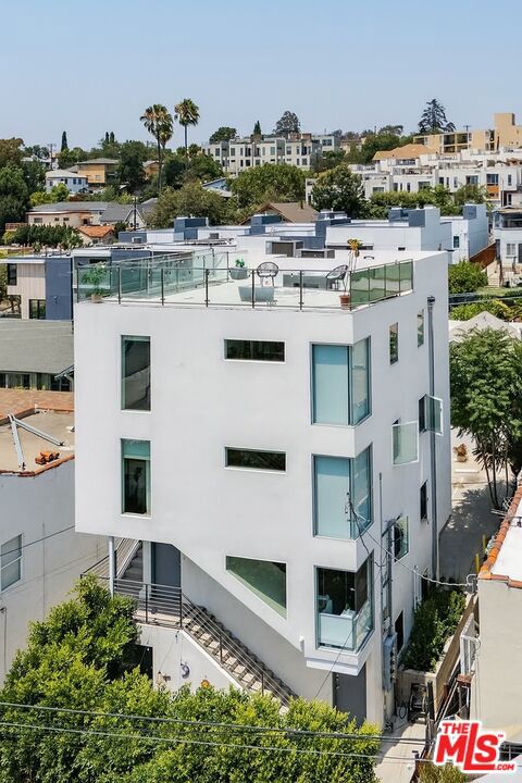 Ideally located in one of LA's hippest neighborhoods, this newly renovated and expanded quadruplex offers a rare opportunity to own a high-quality, income-producing property with breathtaking views of Downtown Los Angeles. Built in 2019, the modern 4-story front duplex, with a 2-car garage, sits privately behind lush hedges and features a welcoming front courtyard. The lower unit is a stylishly designed 1 bedroom with a full bath, perched above a 2-car garage; complete with exposed concrete floors, open-concept living, in-unit laundry, and a dedicated sleeping area. Above it, the expansive two-story top-floor unit with 1 bedroom, 1 bathroom impresses with soaring two-story ceilings and an abundance of natural light. This stunning space includes a spacious open floor plan, engineered hardwood floors, a sleek guest bath, in-unit laundry, and a chef's kitchen outfitted with premium Viking appliances. Upstairs, a primary bedroom, an ensuite spa-like bath, and a separate glass-enclosed office overlook the main living area. Private exterior stairs lead to an incredible rooftop deck with jaw-dropping panoramic views of DTLA and Sunset Blvd. Both front units are tenant-occupied - Upper Unit (1325 1/2) is rented at $4,000/month, and the Lower Unit (1323 1/2) is rented at $2,200/month. Tucked behind the front building, the original 1925 rear duplex delivers quaint charm and privacy. Situated on the right rear side of the property, Unit 1323 features 3 bedrooms, 2 bathrooms, hardwood floors, an updated bath, a shady front porch, and an additional storage space/laundry room below the main living area. Unit 1325 sits just to the left with 2 bedrooms, 2 baths, its own side entry, a hidden front porch, a private back patio, and a spacious storage space below the main living area. Delivered fully vacant, this rear duplex offers excellent upside potential. Projected market rents are $4,000/month for the 3BD (#1323) and $2,500/month for the 2BD (#1325). Just steps from the Elysian Park trails and blocks from the vibrant Sunset Blvd scene, this location offers unbeatable accessibility - grab your morning coffee at the new Goop Kitchen, a mid-afternoon slice at Quarter Sheets, and meet the gang for drinks and a band at Little Joy in the evening, all without getting in your car. With high demand, modern amenities, and immediate rental upside, this is a unique opportunity to own a stylish, income-generating property in one of the Eastside's most desirable neighborhoods.