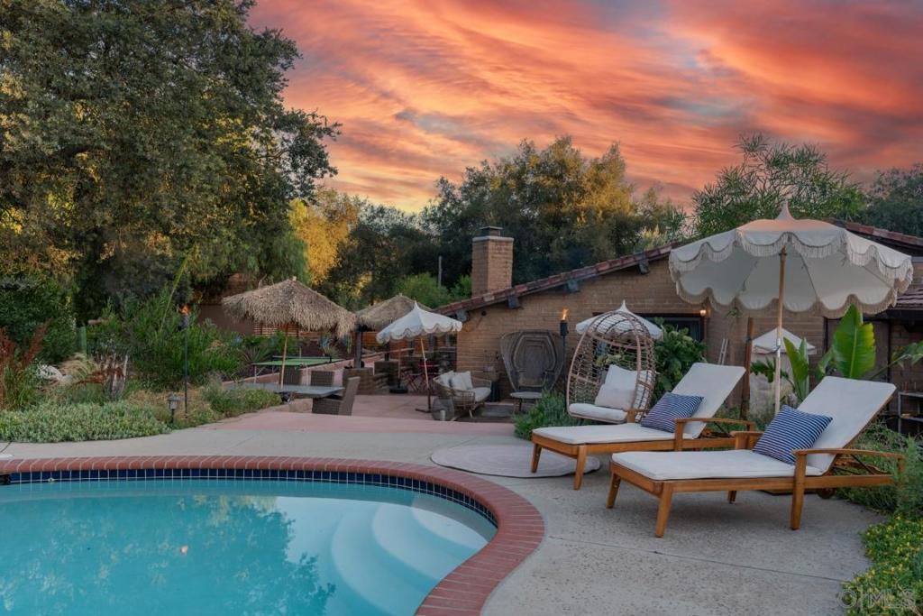 Welcome to 18940 Littlefield Lane—a custom single-level adobe home on 2.47 gated acres, offering 4 bedrooms, 3 full bathrooms and the charm, privacy & functionality rarely found in one place. Whether you're dreaming of a short-term rental, equestrian haven, or hosting private retreats, this property is as versatile as it is magical. Over $300,000 in thoughtfully designed upgrades have transformed this estate into a private compound for relaxation, play, and connection. Equestrian enthusiasts will love the double-horse pasture, tack shed, and secure fencing, For guests or rental potential, two separate trailers offer ideal accommodations for guests. Enjoy a pool with privacy fencing, cabana lounge, basketball court, outdoor kitchen with grill, sink, and dual refrigerator beneath a charming pergola. A 30’ native tipi creates a stunning focal point, surrounded by lush lawn, firepits, and serene pond with waterfall. Flourishing orchard of apples, pears, citrus, stone fruit, and avocado trees, fruiting olive trees, a fragrant rose garden. Water fountains, chicken coop, a vegetable garden, children’s playground, and irrigation throughout, fully PAID solar, Tesla charger and a high-production well! This is more than a home—it’s a lifestyle destination. Charming, playful, whimsical, and truly one-of-a-kind. This home offers endless opportunities to gather, retreat, earn income, or simply enjoy the beauty of your own sanctuary. The property radiates a quaint, country charm that is peaceful and inviting. Don’t miss the chance to own this unforgettable gem!