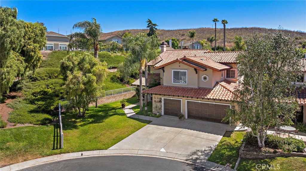 Tucked away at the end of a quiet cul-de-sac in the exclusive gates of Rancho San Juan Estates, this 4-bedroom, 3.5-bath residence captures the essence of resort-style living with a timeless sense of elegance. Surrounded by lush tropical landscaping, the home is designed to be both a serene retreat and an entertainer’s dream. Inside, soaring ceilings and walls of windows flood the open-concept layout with natural light, highlighting upscale finishes at every turn. The gourmet kitchen is the heart of the home, featuring granite countertops, stainless steel appliances, a coffee bar, and an oversized island ideal for casual gatherings. The primary suite is a private sanctuary, complete with a romantic double-sided fireplace, spa-like bathroom, soaking tub, dual vanities, and an expansive walk-in closet. A versatile main-level office can easily transform into a fifth bedroom, while the loft adds a bonus living space. The backyard feels like a private resort—complete with a sparkling pool and raised spa, framed by mature palms and vibrant greenery. A built-in BBQ and generous patio make outdoor entertaining effortless all year long. Additional highlights include a formal dining room, cozy living room fireplace, a 3-car garage with epoxy flooring and storage, and access to exclusive community amenities. The owner has meticulously maintained this property since purchasing it, including multiple exterior painting, roof repairs, water heater, furnace, landscape, hardscape and drainage, fencing, pool equipment, garage painting, flooring, lighting, carpet, cabinets, sinks, toilets, interior painting, insulation, and updated closets. With no Mello-Roos and convenient proximity to scenic hiking and horse trails, San Juan Golf Course, acclaimed schools, charming downtown San Juan Capistrano, the train station, the new Riverwalk Eatery, and nearby beaches, this home offers a rare opportunity to enjoy luxury, comfort, and location all in one. A true turnkey gem for those who want it all.