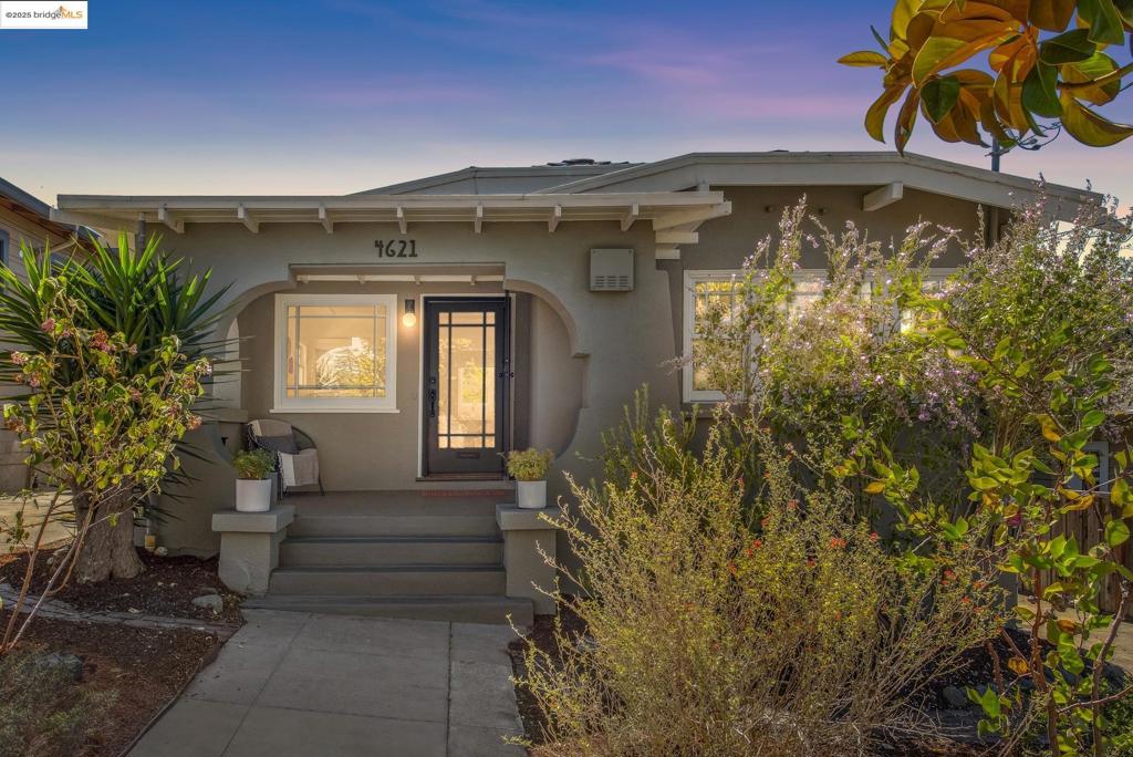 Located in the tree-lined foothills of Maxwell Park, this light-filled Craftsman offers serene living with easy access to the Bay and nearby trails. The charming porch and native garden create a warm welcome, while inside, hardwood floors, preserved Craftsman details, and a freestanding gas stove add timeless character. The flexible layout includes two bedrooms, a full bath with sunken tub, and a half bath with in-unit laundry. The gourmet kitchen features wood cabinetry, a breakfast nook, stainless appliances, and garden views. Recent upgrades include solar panels, Nest-controlled A/C, foundation and drainage improvements. A long driveway leads to a detached, finished garage with AC, heat, water, and power—ideal for a studio, office, or entertaining space*. Enjoy al fresco meals on the deck, garden in raised beds, or gather in the private backyard under the stars. Close to Laurel, Montclair, Mills, and Grand Lake, this home blends comfort, character, and community. *Buyer to investigate.