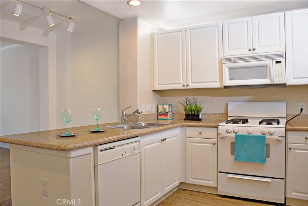 Beautiful Dorchester model located on the 2rd floor with a courtyard and fountain view! This one bedroom one bathroom home features cozy den that could be used as an office, granite counter tops, in-unit stackable washer and dryer, his and her sinks in the master bath. Enjoy soothing breeze from the a large private balcony! The sophisticated living of the Watermarke community offers bounty of amenities including concierge services, business and fitness centers, movie theater and billiards rooms, 3 pools, 4 spas, and an indoor basketball and tennis courts. Gated parking structure with 2 assigned parking spots. Refrigerator and stackable washer and dryer are included in the sale. Come see this cozy condo and make Watermarke your home!