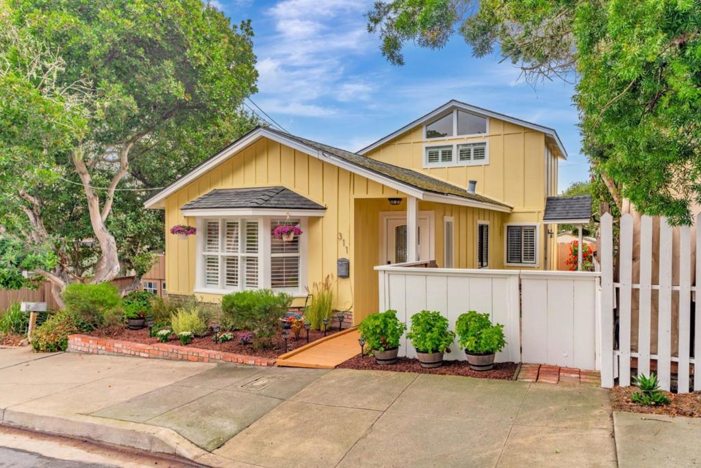 Welcome to Pacific Grove and this delightful residence, located a few blocks from the historic downtown and a few more to a recreation trail and the stunning Monterey Bay coastline. Live the Pacific Grove dream, where you can enjoy all the pleasures of seaside living and the abundant local wildlife, including harbor seals and sea otters, not to mention black-tailed deer wandering around the neighborhood. We are thrilled to present a lovely two-story home with two bedrooms, two bathrooms, hardwood floors, and a private brick patio. An upstairs primary suite comes with high ceilings, natural light and features a balcony with views of Monterey Bay. Morning coffee on the balcony can sometimes be paired with distant whale watching and the calls of sea lions, while evening cocktails come with twinkling city views and the lights of fishing boats. This well-loved sunshine-yellow home shows pride of ownership with all new exterior paint, copper plumbing, a newly restored patio, refreshed landscaping, and new carpet in the primary suite.