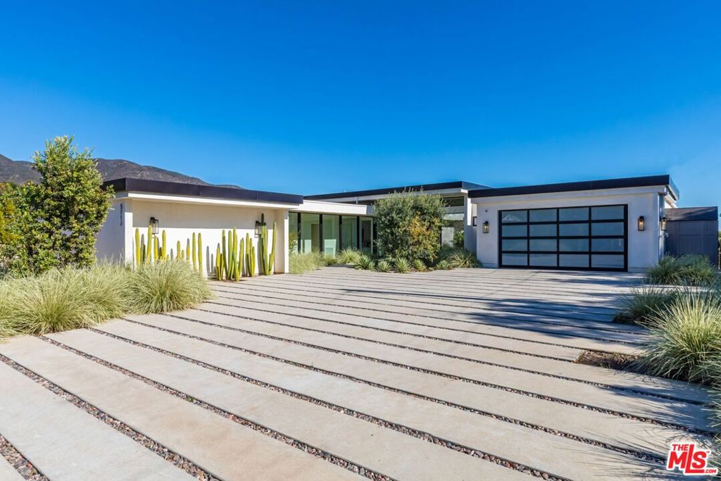 Just completed modern Malibu oasis on over an acre lot with an impeccable floor plan, lush grounds, huge grassy backyard, and views of mountains and the Pacific Ocean. Warm contemporary design with beautiful finishes throughout. This spacious home offers 5 BD, 5BA, and a game room. The living and dining rooms seamlessly blend with the kitchen and have gorgeous natural lighting from floor-to-ceiling sliding glass doors that open for indoor/outdoor living. The patio space has built-in heaters and is perfect for dining al fresco. Additional amenities include a mini ranch, citrus garden, swimming pool with spa, and outdoor space for a sport court. 2-car garage with large, gated driveway for additional parking. This exclusive enclave in prime Malibu Park offers the best hiking and horseback riding in the country. Live minutes from Big Dume State Park and beach and one of the best sandy beaches in all of Southern California, Zuma Beach. Enjoy shopping and dining at the nearby Point Dume Village. This is an incredible Malibu estate, where every day feels like you're on vacation.