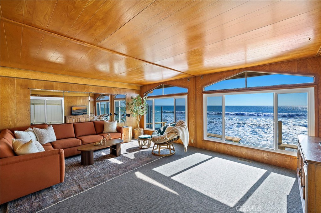 Perched directly on the sand within San Clemente’s private Capistrano Shores enclave, this single-level cottage is a rare midcentury gem awaiting its next chapter. Preserved in remarkable detail, the approximately 1,200-square-foot residence on a 3,075-square-foot lot captures endless Pacific horizons, with unobstructed views that sweep from San Clemente’s iconic pier to the Dana Point Headlands and Catalina Island beyond. Inside, the home embraces its vintage soul—wood-paneled walls and ceilings, intact formica countertops, and original lighting evoke the character and charm of true midcentury design. Expansive windows frame the coastline and flood the living spaces with natural light, while the open flow between living, dining, and kitchen areas makes every moment feel connected to the sea. Two bedrooms and two baths complete the layout, offering comfort today while inspiring possibilities for thoughtful updates or a complete reimagination. Whether restored with reverence for its period details or transformed into a contemporary retreat, the potential here is as boundless as the views. Outside, a generous oceanfront patio leads directly to the sand—an unrivaled vantage point for sunrise coffees, surf checks, and sunsets that paint the horizon in vivid color. Capistrano Shores is a guard-gated community of only 90 homes, celebrated for its rare on-the-sand living and close proximity to the very best of the Southern California coast. From here, surf breaks, beach trails, Dana Point’s harbor, Avenida Del Mar’s dining and shops, and neighborhood parks are just minutes away. 1880 N El Camino Real #38 is more than a home—it’s a preserved piece of California’s midcentury story, set in one of the coast’s most coveted oceanfront settings.