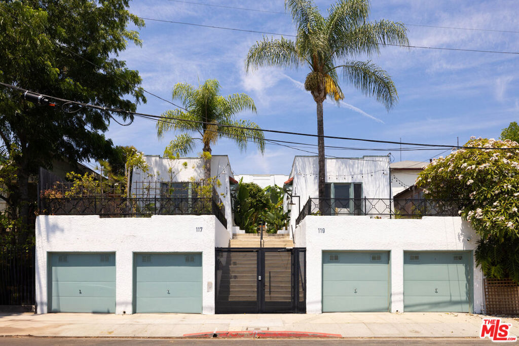 The house stands above the street in a gated Tenants-in-Common community. Tastefully updated, the one-bedroom, one-bath bungalow opens to a living room with hardwood floors, cove ceilings, a decorative fireplace, and large windows that frame views of the Downtown skyline. The deck, exclusive to this unit, is visible below, where you can imagine your future garden beds laden with herbs and lush potted greenery. At golden hour, light reflects off the Downtown towers and illuminates the eat-in kitchen, featuring checkerboard floors, butcher block countertops, open shelving, built-ins, and a backsplash of subway tile that reaches from the counter to the ceiling. A small hallway leads to the laundry area, which has sufficient room for utility shelving, and the bedroom, featuring an en-suite bathroom. Zia tile lines the bathroom floor and surrounds the combination tub/shower, complemented by Hans Grohe fixtures and a Duravit sink. Located near the center of Historic Filipinotown's thriving culinary and cultural scene, you'll enjoy Woon, Doubting Thomas, Gigi's, Brooklyn Bagel, 2220 Arts + Archives, and its close proximity to Silver Lake, Echo Park, and other beloved neighborhoods.