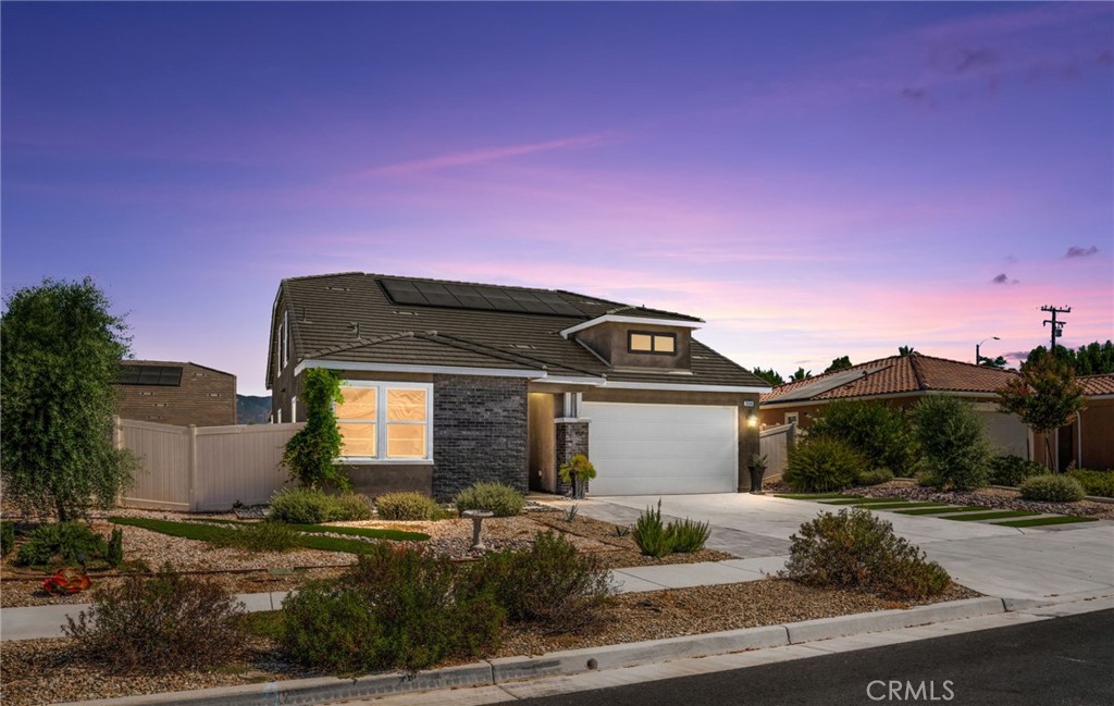 Welcome to this energy-efficient modern home in the heart of Loma Linda, one of the world’s five original Blue Zones known for healthy, intentional living. Built in 2021 with thoughtful upgrades throughout, this 4-bedroom, 3-bathroom home offers over 2,500 square feet of well-designed living space. Step inside to soaring 10-foot ceilings and an open concept floor plan that blends the kitchen, dining, and living areas. The kitchen features crisp white cabinetry, quartz countertops, a deep farm-style sink, and stainless-steel appliances. Three bedrooms, including the primary suite, are located on the main floor. Upstairs offers added privacy with a fourth bedroom, full bath, and built-in desk and storage. An ideal layout for remote work, multigenerational living or space for guests. The front yard is beautifully zero-scaped with drought-tolerant plants and an automatic Rainbird drip system. Out back, enjoy a low-maintenance yard with artificial turf, a decorative garden wall with river rock accents, a spacious covered paver patio with lighting and ceiling fans, perfect for entertaining or quiet evenings under the stars. Additional features include built-in closet organizers, a tankless water heater, and a 2-car attached garage. The home is also equipped with paid solar, helping you keep utility costs low while living more sustainably. The location is hard beat, just five minutes from Loma Linda University Medical Center and easy access to local microbreweries, bakeries, and some of the best restaurants in the area. What you'll love most though, is the community feel on a street with truly great neighbors. This is thoughtful living, inside and out.