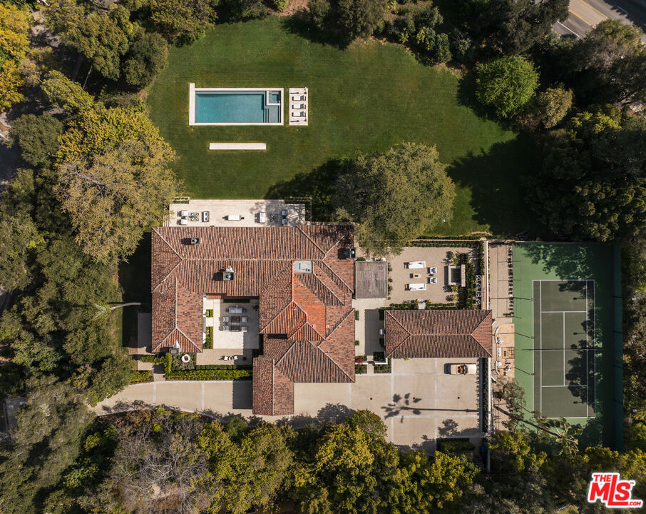 A rare opportunity to experience one of most prestigious residences in the heart of Holmby Hills. Built in 1929, this timeless Spanish estate has been meticulously designer renovated. Set on a sprawling 2 acre lot with a championship size tennis court, brand new pool, and an expansive grass lawn. The property features four spacious bedrooms, all thoughtfully designed while preserving the classic, original architectural details. Each bedroom is en suite with Waterworks fixtures and walk in closets. The primary suite is a private retreat, offering dual walk in closets, dual bathrooms with steam showers, and breathtaking garden views. The formal living and dining rooms exude elegance with reclaimed wood floors laid in a herringbone pattern. The chef's kitchen is equipped with top tier appliances, custom cabinetry, and a large center island. The charming guest house is ideal for hosting or extended stays. The meticulously manicured gardens and mature trees provide a serene escape while still being moments away from the vibrancy of Beverly Hills dining and shopping. 115 N Carolwood Drive offers the perfect combination of history, elegance, and luxury living with modern day amenities. First time on the market.