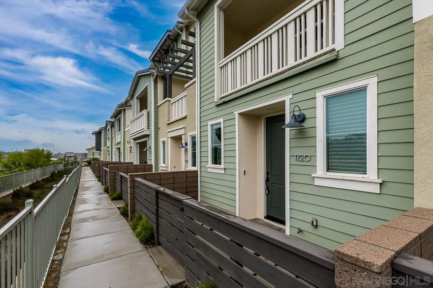 Welcome to this beach-close, west-of-the-5 townhouse in The Tides Complex. This modern residence offers a well-designed 3-bedroom, 2.5-bath layout with approximately 1,775 square feet of comfortable living space. Eco-conscious features include owned solar panels, an ECO water heater, and electric vehicle hookups in the private two-car garage. Inside, elevated finishes include wood and tile flooring, high ceilings, luxury appliances, and an open kitchen that flows seamlessly into the family room.  Upgrades throughout the townhome include owned solar, an ECO water heater, Nest-controlled AC, electric vehicle hookups, and a striking 13-foot quartz island. Luxury vinyl flooring runs throughout, complemented by custom inlay tile on the stairs, a designer kitchen backsplash, curated lighting, and a custom barn door in the third bedroom. Thoughtful storage is built in, including custom closets, overhead garage storage, and an oversized tandem garage with workspace. The kitchen is anchored by a Bertazzoni range and upgraded stainless steel appliances. Built in 2019, the desirable Tides Complex features gated entry, a clubhouse, and a resident pool. Off-street parking for two vehicles and an upper-level laundry area add everyday convenience.