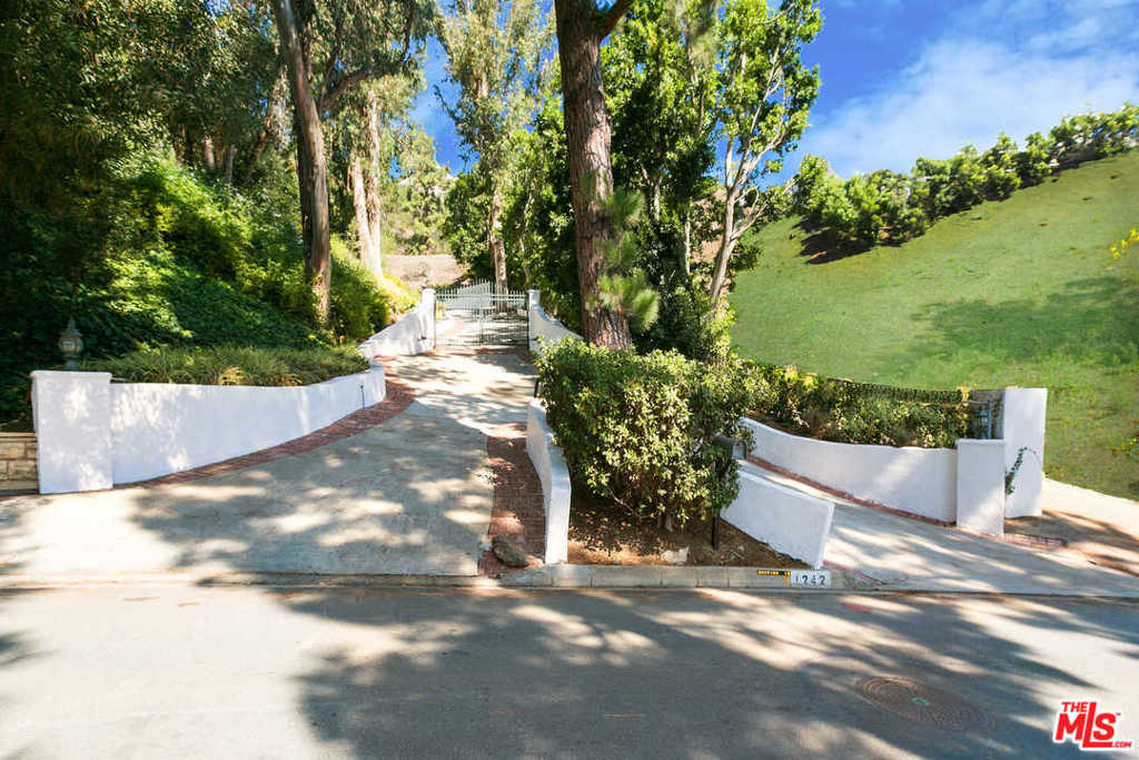 Two huge separate lots with views in Beverly Hills proper! These properties are gated up a long majestic driveway, which opens up onto the two huge legal lots with views. Nestled on one lot is a charming 5,950 square foot house with a swimming pool. The other lot has a huge flat pad with canyon and city light views. This is a great find for a developer to build two spec houses or a fantastic opportunity for an owner-user to build a fabulous private compound in Beverly Hills proper, directly across the street from a $30 million estate.