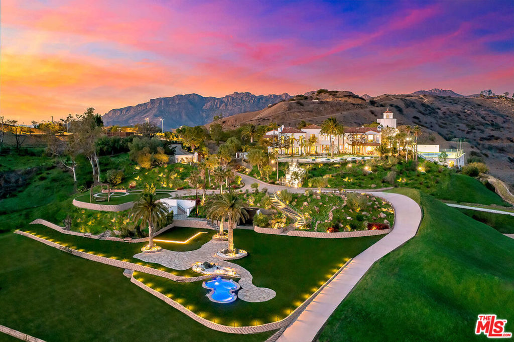 Introducing the iconic Malibu Dream Resort, a signature vineyard estate nestled atop its own secluded mountaintop. Spanning roughly 10,000 square feet, this grand residence echoes the lavishness of a classic Italian Villa, marrying timeless grandeur with the pinnacle of contemporary comfort. It offers unrivaled panoramic views of the Santa Monica mountains and the Pacific Ocean. Set within 45 untouched acres, and approximately 10 acres of flat land, the estate is approached via a private driveway, leading to the villa's grandeur. The interior boasts cathedral ceilings, polished hardwood floors, stone countertops, a professional-grade kitchen equipped with the latest appliances, and an additional prep kitchen. The master suite is a sanctuary of luxury with a spa-like bathroom, salon, and spacious walk-in closets for both. Accommodations include six plush guest suites, a media room, gym, and an expansive garage for eight vehicles. Outdoor living is redefined here with extensive stone terraces, a loggia with a fireplace and dining space, all extending to a spectacular pool and spa. This estate features the largest residential flat land in Malibu, enhanced by exquisite koi ponds, and offers views over Malibu's wine region and fruit orchards. The estate encompasses six individual parcels, showcasing its unmatched exclusivity. A dedicated house manager, with 25 years of service, resides in a separate guest house, ensuring meticulous upkeep. This estate is not only a magnificent residence but also presents an ideal opportunity for a retreat or treatment center, offering unparalleled privacy and luxury. For inquiries regarding short-term rental pricing and availability, please contact us. Discover the unique allure of this must-see Malibu estate.