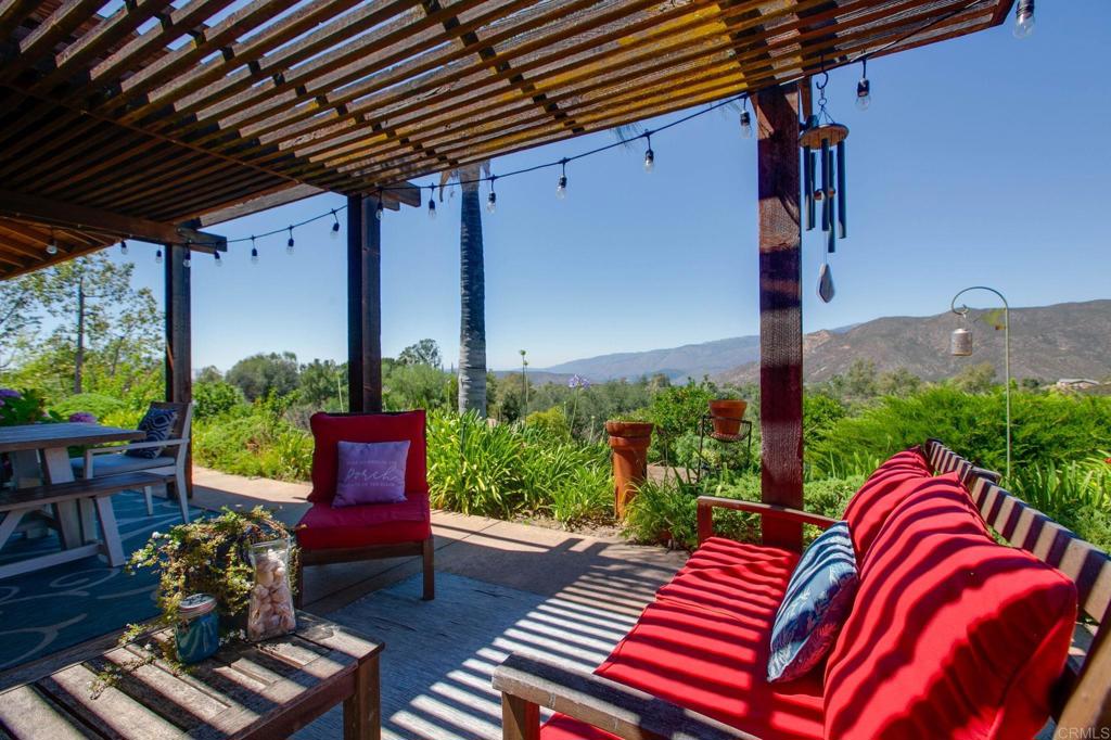 Welcome to a True Country Retreat with Modern Flair and Panoramic VIEWS! This Single Story Home offers 2,142 sqft of living space on 2.4 Fully Useable Acres. Located at the end of a private road with no through traffic, just peace and quiet! Beautifully Renovated with Exquisite Wood Floors and Dramatic Vaulted Ceilings w/Wood Beams throughout. The Spacious Family Room centers around a Stunning Stone Fireplace, perfect for cozy evenings. Remodeled Kitchen opens to the Family Room and features Stainless Steel Appliances, abundant Counter Space, Pantry with Sleek Pull out Drawers and a Farmhouse sink that adds timeless charm. The Large Primary Bedroom offers Breathtaking Mountain Views, a generous Walk-in Closet and the added charm of a pellet stove for extra warmth and ambiance. Indulge in a luxurious Primary Ensuite designed for relaxation and style. Dual sinks for effortless morning routines, a beautifully Tiled Walk-in Shower and a Free Standing Tub perfectly positioned by the window to take in the scenic views. Outside you can relax on the Full Length Patio, perfect for morning coffee, evening unwinding or hosting friends in a quiet, scenic setting. Next to the patio is a versatile Standalone Structure with its own foundation, windows for natural light and A/C for year round comfort. Perfectly suited for an office, craft room or welcoming guest space. Car enthusiasts and hobbyists will love the 3 car garage plus the impressive 1,000 sqft RV Garage/Workshop featuring 220V Single-phase power and RV Clean out. The workshop also has 2 rooms inside with a dedicated 50 amp Sub-panel which can be used for an office/storage. The grounds are Fully Fenced and include a garden with raised beds, 2 sheds and over 60 different fruit trees. There is plenty of room for an ADU or pool.