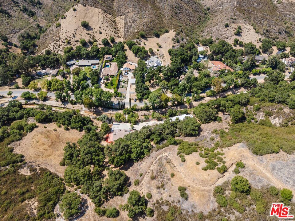 Tucked along Stokes Canyon Road, this gated ranch property features two dwellings, a workshop barn, and is accessed via a private bridge leading to a serene 1.25 Acre lot with mature oak trees - a unique Calabasas opportunity. The 4-bedroom, 3.5-bathroom main house has been partially demolished and requires restoration work to restore. There are two detached guest cottages, along with a 4-car garage and large metal workshop / barn. The property comes with adjoining 1.19 Acre lot, allowing adequate space for additional dwellings, a pool or tennis court. This property will appeal to the country living equestrian buyer, who appreciates the outdoors and peaceful tranquility of the serene Calabasas mountains.