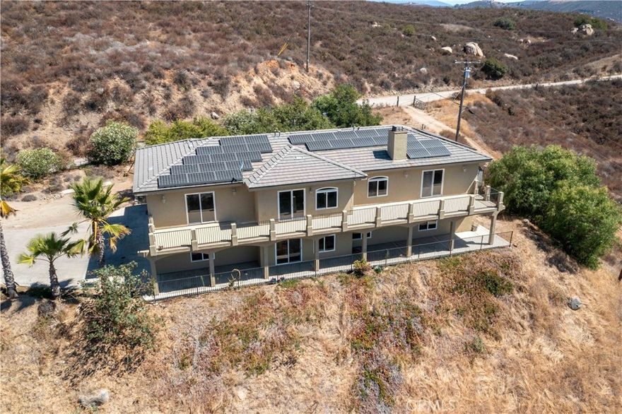 Stunning Hilltop Retreat with Panoramic Views!  This impressive two-story home offers 4 bedrooms, 5 bathrooms, and 4,386 sq. ft. of living space on a 5.22-acre lot. Elevated on a hilltop, the property provides breathtaking panoramic mountain views and exceptional privacy, while remaining conveniently located between Julian and Santa Isabel, near San Diego Country Estates, and just minutes from local vineyards and wineries.  Inside, the open-concept living room features a cozy fireplace, crown molding, recessed lighting, and a balcony to take in the sweeping views. The kitchen offers granite countertops, a large island with breakfast bar, custom wood cabinetry, stainless steel appliances, walk-in pantry, and sleek tile floors. A separate dining room creates a warm and inviting space for hosting gatherings and entertaining guests.  The first floor includes a convenient bedroom and full bath, laundry room with washer and dryer, and direct access to the 4-car garage. Upstairs, a spacious loft, multiple ensuite bedrooms with beautifully tiled showers, bathrooms with double sinks, and several walk-in closets offer plenty of space and comfort for everyone.  Additional highlights include central air, ceiling fans in most rooms, newer carpet and fresh interior paint, a reliable backup generator, private well, septic, and propane system. The property also features an income-producing Vertical Bridge cell tower (disguised as a tree), offering a rare opportunity for passive revenue. Zoned A72, this home is perfect for those seeking a rural lifestyle.  Opportunities like this don’t come often - with motivated sellers, now is the moment to secure this rare hilltop gem!