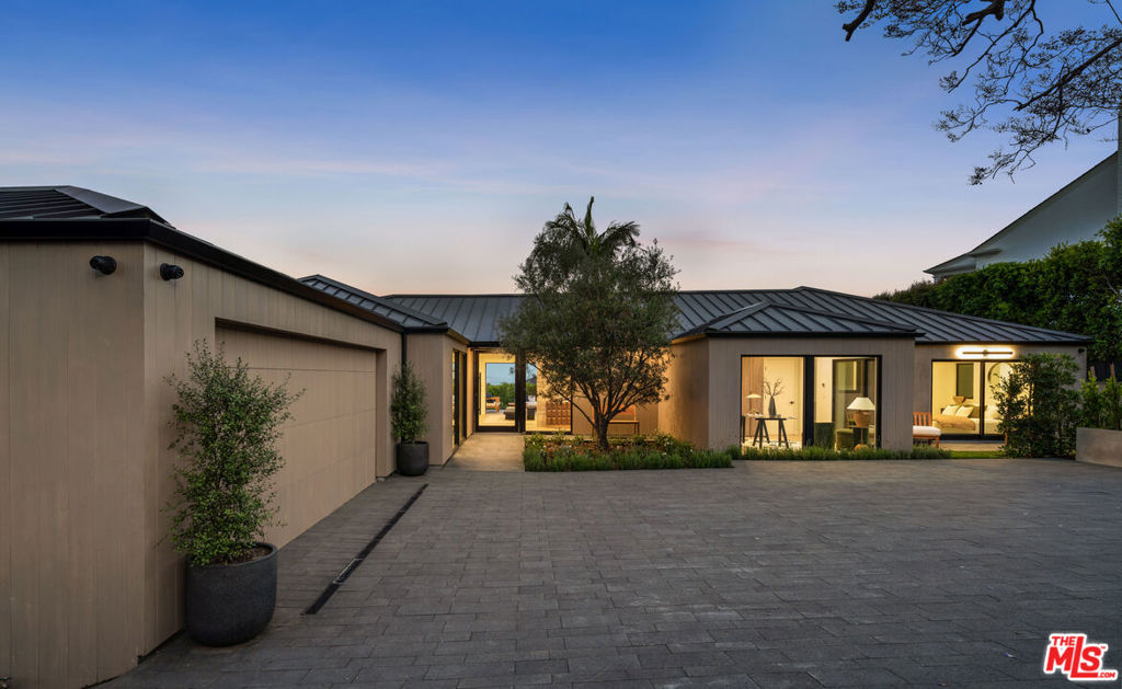 Located on one of the most desirable streets in the prestigious Palisades Riviera, this warm, contemporary marvel was designed with elegance and comfort in mind. Gated pedestrian and vehicular entries along with lush landscaping provides privacy and security. Approaching the glass front pivot door, you encounter your first glimpse of the meticulous design elements that await you in the home. A stunning travertine-clad wall frames the open concept kitchen and family room. The commodious kitchen features gorgeous rift-oak custom cabinetry, a large marble-clad island, state-of-the-art Miele appliances, and a marble-clad breakfast table. Past the kitchen, a hallway lined with copious cabinetry and storage leads to a well-appointed butler's pantry that serves directly into the spacious dining room that houses a showcase refrigerated wine display niche. The open concept kitchen and family room feature metal doors that pocket and slide to seamlessly connect the space to a gigantic terrace with stunning ocean views to the south (on a clear day one can see the cranes in the port of Long Beach) and mountain and cityscape views to the east.A magnificent powder room with a floating marble vanity and multiple coat closets line the front hall as you head towards the home office (which includes en-suite closet and bathroom), two secondary bedrooms with en-suite closet and bathroom, and the primary suite. The primary suite boasts two walk-in closets, two separate and enclosed water closets, two separate vanities including a makeup counter, an enormous stone-clad shower, a soaking tub, and a private patio with picturesque views of the backyard and beyond to the City and ocean.The lower level features a wealth of additional living and entertaining spaces. A private fitness center with en-suite bathroom provides the ideal environment for a meditative yoga session or a high intensity workout. A spectacular screening room with an extra large projection screen and state of the art surround sound is ready to showcase your favorite TV show or movie. Accessible from a private entrance, a staff room with en-suite bathroom opens to the laundry room. A spacious entertaining/game room features a long marble bar with glass shelves and ample space for billiards or table tennis. Sliding doors connect the space to a covered loggia with multiple seating vignettes that acts as your introduction to the backyard. Stroll over to the built-in outdoor kitchen and grill, take a dip in the oversized pool with built-in spa, relax on a lounge chair, or kick around a ball on the expansive lawn.From the seamless flow of the living spaces to the exquisite finishes, this residence offers an unparalleled living and entertaining experience. Do not miss out on this once-in-a-lifetime opportunity to live in one of the most beautiful homes in one of the highly desired locations on the Westside.