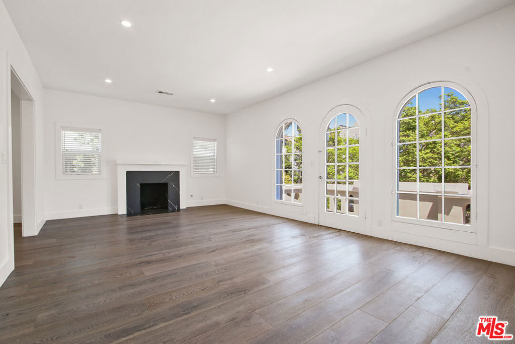 LISTED AT $5,895/MONTH. NET EFFECTIVE RENT IS APPROXIMATELY $5,405 /MONTH BASED ON A 12-MONTH LEASE WITH ONE MONTH FREE (SUBJECT TO APPROVED CREDIT. SECURITY DEPOSIT IS $5,895). Built in 1925 and beautifully remodeled, this rare upper-level residence offers 2 bedrooms and 2.5 baths in an exclusive two-unit duplex, giving you unmatched privacy in one of LA's most coveted neighborhoods. Just steps from Melrose Place's boutiques, cafs, and iconic Sunday farmers market, yet tucked away on a quiet tree-lined street, it's the perfect balance of excitement and retreat. Sunlight pours through arched windows onto wide-plank hardwood floors, highlighting the spacious living room with a stone fireplace and French doors that open to a large treetop balcony, creating a serene, treehouse-like escape. The updated chef's kitchen features sleek white cabinetry, high-end stainless steel appliances, and flows seamlessly to a formal dining room for effortless entertaining. Both bedrooms are generously sized, with the primary suite offering a spa-like bath. Enjoy in-unit laundry, central HVAC, and a covered garage space with storage plus an additional uncovered spot. A rare opportunity to live in a piece of LA history, reimagined for today's lifestyle.