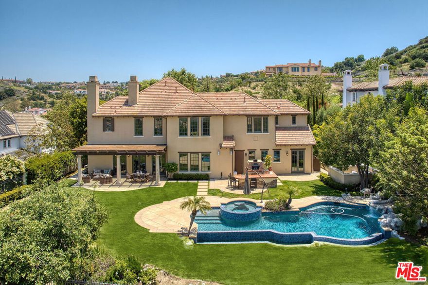 Welcome to the coveted Oaks of Calabasas. This is your chance to secure a view home perfect for family entertaining and parties. This Reserve 2 model is perfectly situated on Prado de las Fresas to capture spectacular views. Pull a great bottle from the wine cellar and enjoy a fresh pizza from the pizza oven before you head off to a movie in the detached theater. The grand 2-story entry welcomes you to a window filled formal living room with fireplace on one side and a large, elevated loft on the other. The formal dining room features a custom-built professional wine cellar with an 1800+ bottle capacity. A central outdoor courtyard with a fireplace beckons to complete the perfect evening. The great room combo kitchen/family room with beautiful limestone flooring flows out to the yard through French doors. The spacious eat-in kitchen done in oak and quartz has a center island, Viking and SubZero appliances, an ice maker, desk and butler's pantry that features a Miele coffee station and 4 additional mini fridges. It also has a generous eat-in area with views and a walk-in pantry. The family room with fireplace and built ins is seamlessly connected to the kitchen and yard. One en-suite bedroom, laundry room and powder room are adjacent. An attached casita with mirrored walls and an en-suite bath has French doors that open to the pool and is perfect for a gym, office or additional suite. The separate theater seats six in luxury stadium seating. Upstairs there are 3 large bedrooms, all featuring en-suite baths and an open bright family room. The primary retreat features an office nook with fireplace and takes in the gorgeous views. The primary bath is pristine in marble and oak and has dual closets and built-ins. The sweeping yard combines the right combination of custom infinity pool with slide and fountain, elevated spa with water feature, covered loggia for relaxing and enjoying the views, central BBQ bar and pizza oven and plenty of grass for activities. The view extends for miles and incorporates sunsets and city lights.