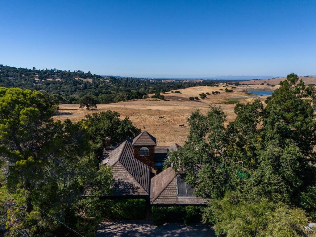 This exquisite property, in Santa Clara County w/Palo Alto schools captures the essence of Portola Valley on a spectacular 1.28 +/- acre lot. Boasting scenic beauty of Stanford hills and Felt Lake this home features a 1695 +/-sf single-level guest house w/ground-level access. With 3 beds, 3 bas, office and bonus room in the 4146 +/- sf main residence and 3 beds, 2 bas in guest house, plus 2-stall horse stable, this home provides versatile living options. Remodeled by RJ Dailey in 1983, the main homes exquisite structural beamed ceilings and custom windows perfectly frame the view of the surrounding open space and glorious sunsets. Cool tile and warm wood floors enhance the open floor plan and newly carpeted bedrooms provide comfort. Kitchen is large and bright w/luscious views. A separate guest house, accessible via its own driveway, offers independent living. High ceilings and large great room are complemented w/updated eat-in chefs kitchen and granite counters. The primary suite features, spa bath, luxurious soaking tub, 2 walk-in closets and storage loft. Each home features a 2-car garage and the guest house also includes a workout room/office and workshop.This property offers a tranquil sanctuary near hiking and biking trails, Rossottis Alpine Inn and Ladera Country Shopper.