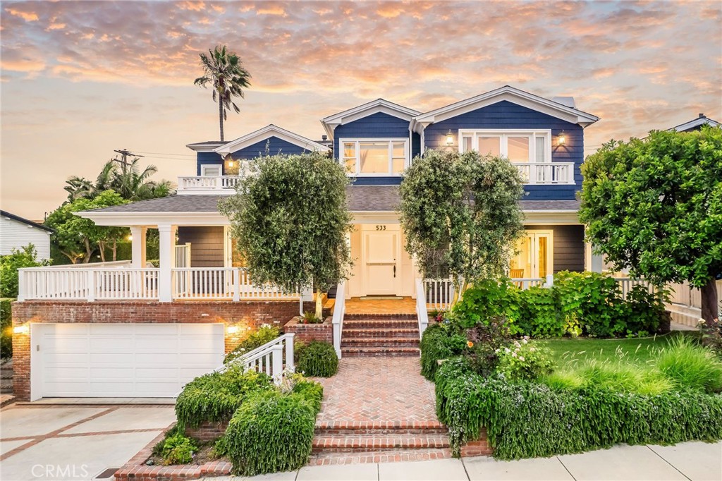 Welcome to the ultimate coastal estate – 533 15th Street, a stunning residence located on the American Martyrs Hill and offering six bedrooms and seven baths in approximately 5300 square feet of premium living space. This expansive home, custom built in 2004 with designer finishes at every turn, is strategically sited on a 7702 square foot lot, perfectly positioned to take in ocean views from Palos Verdes to Catalina and beyond. Special touches such as a hand-carved spiral staircase, a Dutch front door, coffered ceilings, two inviting fireplaces, and a three-stop elevator make for advantageous living just steps from Live Oak Park, DTMB, and the Strand. A light-filled formal living room boasts a cozy fireplace and French doors to the veranda, while the formal dining room features handsome custom millwork and built-ins, perfect for hosting and entertaining. The open-plan family room includes built-ins and a fireplace with a separate seating area, while the first-floor bedroom is flooded in natural light. A gorgeous backyard with pool, a built-in fire pit and barbeque provides a private oasis for family and friends. The kitchen is resplendent with a large center island (including an expansive breakfast bar), a walk-in pantry, Butler’s pantry, stainless appliances, and a charming seating area overlooking the backyard. Tucked away on the basement floor, the media room offers the ultimate retreat with a state-of-the-art projector and ample space for a game table, while a convenient gym is found in the garage. Upstairs, the Primary suite features a cathedral ceiling and a large ocean-view balcony, and includes a custom, spa-like Primary bath. Second-floor bedrooms are sunny and bright and house wainscoting as well as views of the Pacific, and all baths contain designer tiles, fixtures, and finishes. Additional amenities abound, from a charming laundry room to a three-car garage, to the comforts of central air and a locale second-to-none. A spacious, covered front brick veranda and a generous side patio with ocean views and a built-in heater are just a few of the comforts of this beautiful home perched on a hill, created to provide stylish living in the center of storied Manhattan Beach.