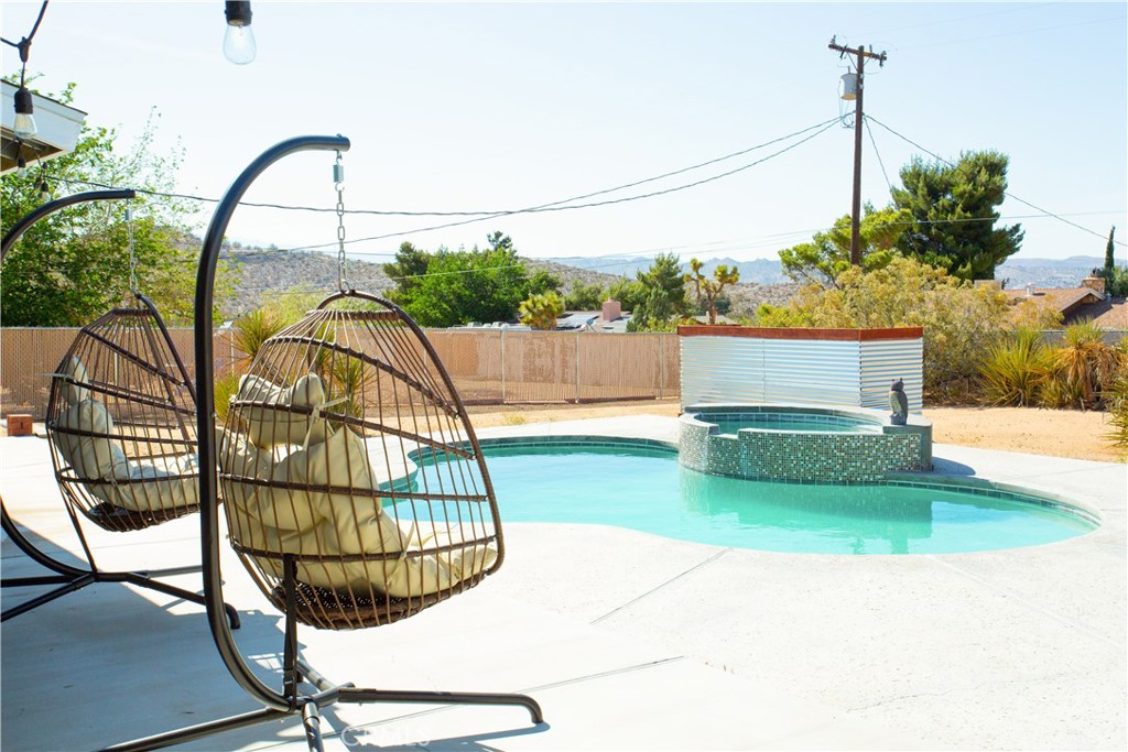 Welcome to this beautifully maintained, turnkey pool home in the highly desirable Sky Harbor neighborhood of Yucca Valley. This 4-bedroom, 2-bathroom home offers an inviting layout featuring an updated kitchen, modernized bathrooms, two separate living areas, and a large primary suite. The open-concept design flows seamlessly into the stunning backyard. The sparkling pool, upgraded with a newer heater and equipment, is surrounded by mature trees creating a private oasis perfect for family gatherings or relaxing evenings. Practical upgrades, including a newer HVAC system and newer roof, provide peace of mind, while the home’s proximity to nearby trails makes it ideal for an active lifestyle. Your private oasis awaits!