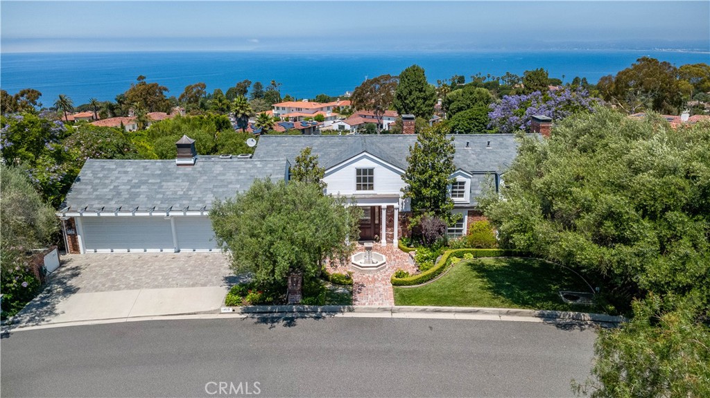 Located in the heart of Montemalaga—one of the most sought-after neighborhoods for luxury estates in Palos Verdes Estates—this stunning Colonial-style residence showcases elegance, sophistication, and absolute privacy on one of the most unique lots in the area. Extensively remodeled with high-end finishes (most recently in 2013), this custom home offers expansive ocean and coastline views, an inviting courtyard entry with a tranquil water fountain, and a grand foyer illuminated by a Bohemian Crystal Chandelier. Throughout the home you’ll find 8” wide-plank walnut hardwood floors, and exquisite Enkeboll Design staircase banisters and molding that elevate the craftsmanship and design. The formal living and dining rooms overlook beautifully landscaped grounds and panoramic ocean vistas. The chef’s dream kitchen features a Wolf professional range and top-of-the-line stainless steel appliances—ideal for entertaining in style. The private master suite is a serene retreat, complete with a cozy sitting area, fireplace, and breathtaking views of the gardens and Pacific Ocean. Two spacious family rooms provide flexible living areas, perfect for gatherings and everyday comfort. The lush backyard is an oasis of tranquility, featuring an expansive brick patio, wood-burning fireplace under a charming open-beam portico, a copper-roofed gazebo, peaceful walking paths, fountains, and meticulously manicured gardens. The resort-style pool and spa, along with built-in BBQ area (gas and wood-burning), make this estate ideal for entertaining year-round.
Offering exceptional design, absolute privacy, and estate-like grounds, this residence embodies the best of Palos Verdes Estates luxury living. Seller Financing or Lease Option Considered.