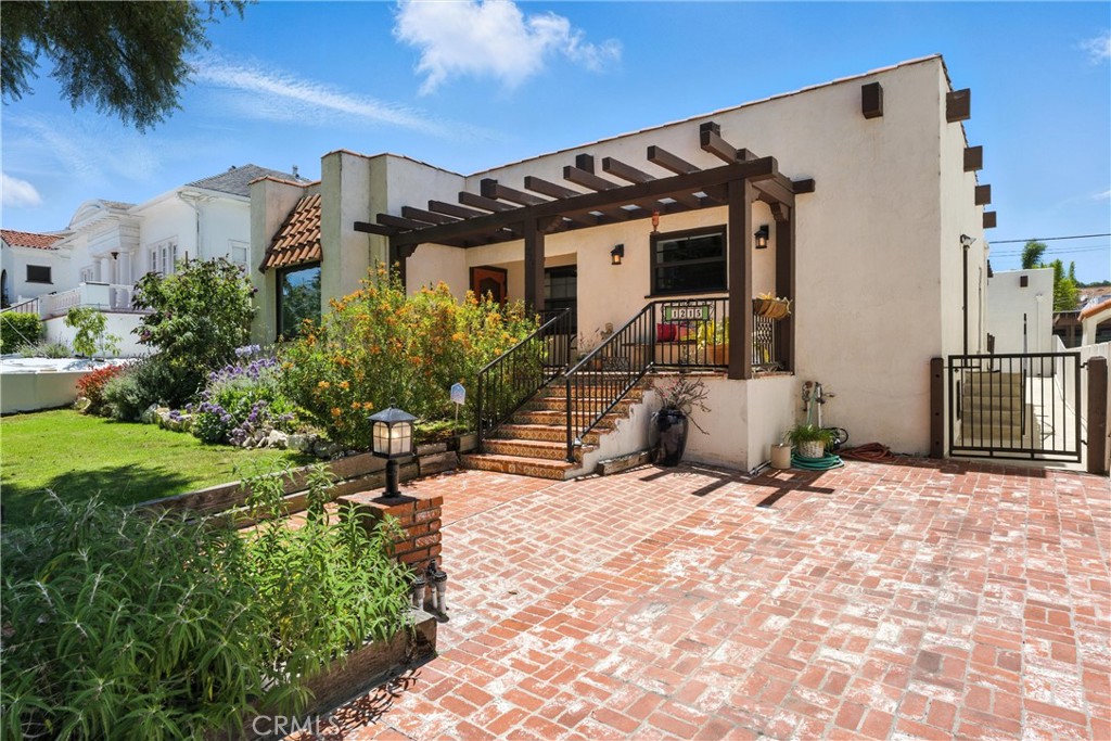 Welcome to this 1947 Spanish/Mediterranean dream! This house just oozes charm and style from the moment you arrive with curb appeal galore! Step through vintage iron gates and a brick walkway leads to a cozy front porch where you can sit and chat with your neighbors on this beautiful tree-lined street! As you enter, you’ll be taken by stunning wood beams and original hardwood floors. A beautiful fireplace framed with colorful Spanish tile is the focal point of the room, and a beautiful picture window lets the natural light shine through! The kitchen is a chef’s delight! Bursting with color, it features cabinet and counter space galore, a large center island, a full wall of pantry storage. There is a double oven, a 6-burner cooktop, 2 compartment ceramic farmhouse sink, and an upscale 4 door refrigerator, all illuminated by a large skylight. A tucked away laundry area adds to the thoughtful design. Two spacious bedrooms and two large baths are located off the hallway; both bedrooms have large closets and mini-split heat/ac units. Out back, your private oasis awaits! You’ll step out onto a wood deck where you can sit and enjoy the warm summer evenings and then walk into an absolute gardener’s delight! The space abounds with color and features a spacious “summer house” where you can entertain family and friends and host your summer barbecues! Beyond that is a large, raised bed area, affectionately called “The Farm”, where you can let your green thumb come alive! Parking will never be a problem here – a spacious 2-car garage has alley access and a driveway large enough for multiple cars, and there is also an additional front driveway. Upgraded Milgard dual-pane windows have been added for energy efficiency and functionality. This location is everything you could want – grab a quick lunch at Weymouth Corners and relax at iconic Averill Park which is just a short stroll away! Come discover the hidden gem that is San Pedro – one of the last affordable waterfront communities!