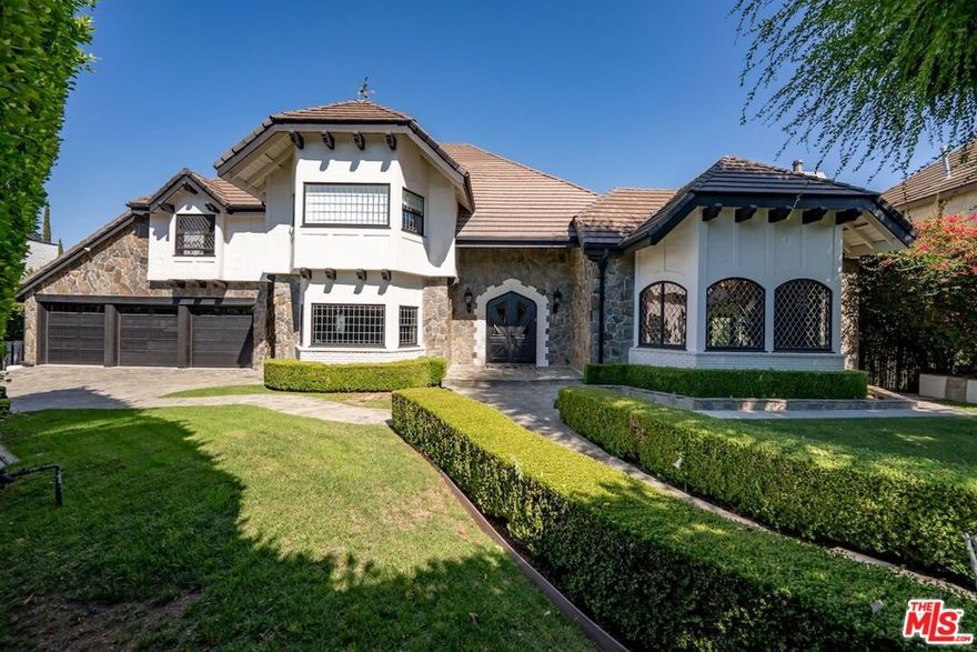 Experience everyday luxury living in this gated French Manor Estate, nestled in one of the most coveted neighborhoods of Encino Hills South of the Blvd. This exceptional residence captures sweeping city-light views and spans over 8,900 square feet of exquisite living space, featuring six bedrooms and eight bathrooms. Completely remodeled, the home blends elevated design with meticulously curated upgrades for comfort, style, and effortless entertaining. Upon arrival, guests are welcomed through a spacious courtyard into a grand entry filled with natural light and soaring ceilings. The great room showcases custom built-ins and coffered ceilings, while the living room's exposed beams create a warm, sophisticated ambiance. The private formal dining room, framed by expansive French windows, seamlessly connects to a butler's kitchen for ease of service. The gourmet kitchen is a chef's dream, appointed with top-tier appliances, a generous island, and a farmhouse sink overlooking tranquil city views. Upstairs, the expansive primary suite serves as a private sanctuary with a spa inspired bathroom featuring an oversized jet shower, double vanities, a fireplace, a large walk-in closet, and a private terrace framing the spectacular views. Three additional en-suite bedrooms complete the top level. Descending to the third level reveals an entertainer's haven with a state-of-the-art theater, an elegant billiards room with terrace access, a sauna, a library, and a climate controlled wine cellar. The outdoor spaces are equally impressive, featuring a sparkling pool, fireplace, basketball court, and pool house perfect for year-round gatherings. This is a residence of unmatched caliber that must be experienced in person to be truly appreciated. Schedule a private showing today and witness its beauty firsthand.