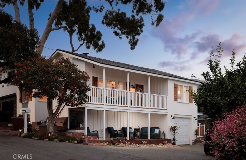 Step into a piece of Laguna Beach history with this quintessential 1930’s board-and-batten cottage, perfectly positioned in the heart of South Laguna. This two-bedroom, one-bath ocean view home is filled with character, natural light, and timeless details—all just a short stroll to Table Rock, Thousand Steps, and West Street beaches, as well as the world-class Montage Resort.
Inside, the home features a bright, airy kitchen, cozy living spaces, a grand wood burning fireplace and a loft offering additional room for guests, a Sunday nap, or creative retreat. Every room is framed by windows that bring the coastal views and ocean breezes indoors. A convenient one-car garage adds valuable parking and storage—an uncommon find in this beach-close location.
Multiple outdoor spaces set the stage for relaxed entertaining and everyday enjoyment. Gather on the wide front porch, shaded by mature trees, host friends on the private patios, or take in sunsets from the elevated deck.
This property offers flexibility for every lifestyle—whether as a full-time residence, a beach escape, or an investment opportunity. With room to expand, the existing footprint provides an ideal opportunity to add an income-producing ADU.
Enjoy everything Laguna has to offer right outside your door—local restaurants, coastal trails, and the trolley that connects you to the vibrant energy of downtown.
This is a rare opportunity to own an authentic piece of Laguna Beach history where charm, character, and opportunity meet the California coast. Exclusive viewing by appointment only.