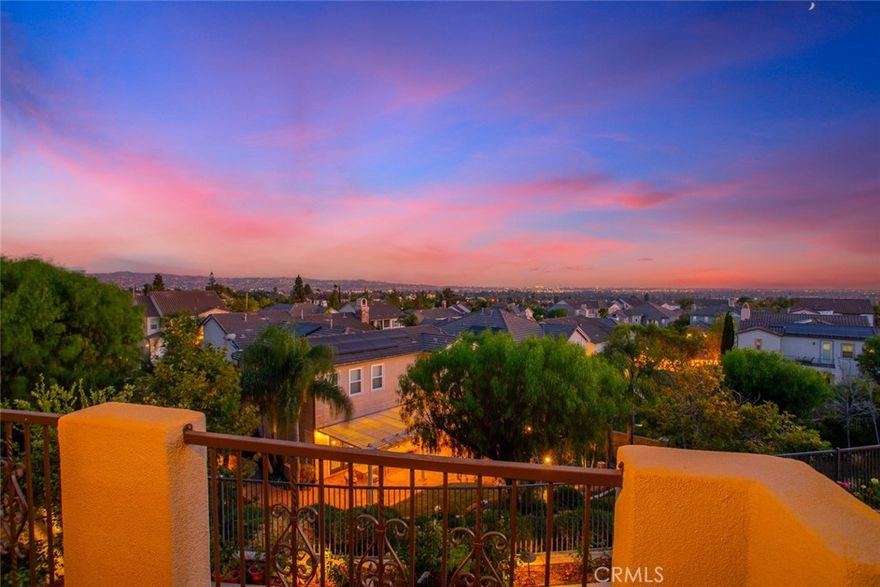This turnkey estate, featuring distinguished Spanish architectural elements, is located within the prestigious Foxfield development of Vista del Verde. Model 2 offers a highly desirable floor plan with thoughtful upgrades that suit various lifestyles. The residence encompasses 3,920 square feet of living space, including four spacious bedrooms and two and a half bathrooms, as well as an attached ground-level in-law suite (5TH Bedroom) with a private bathroom and separate entrance for added versatility.

Upon entering the grand foyer, residents are welcomed by soaring vaulted ceilings and an open living room anchored by an arched gas fireplace with a pre-cast concrete mantel, surround, and hearth. Architectural highlights include dramatic ceilings, soffits, graceful arches, and a custom-crafted staircase with stained maple handrails and upgraded wrought iron balusters.

The home features a large interior laundry room equipped with a deep sink and custom storage cabinetry. The gourmet kitchen is designed with a center island overlooking the dining area, extensive custom storage, a walk-in pantry, a five-burner cooktop with vented hood, double oven, built-in refrigerator, microwave, and dishwasher. The elegant dining room, bathed in natural light, is ideal for entertaining.

Upstairs, the builder-option loft creates an inviting and flexible space suitable for a game room, office, study area, or home gym. The master suite includes a luxurious bathroom, private dressing area, walk-in closet, dual sinks, an oval soaking tub, and a separate walk-in shower. A walk-out balcony from the master bath provides impressive sunset and city light views.

The backyard is designed for entertaining, with drought-tolerant landscaping, concrete pathways, a rose garden, a covered patio with an island, and a stainless steel BBQ with an additional burner and sink. The exterior is enhanced by stone accents, ornamental wrought iron fixtures, wood shutters, and elegant arches.

The in-law suite stands out as a valuable amenity, offering private access, a spacious closet, a niche for a living area or office, and a full bathroom. This meticulously maintained home exudes charm and warmth, presenting an excellent opportunity for discerning buyers.