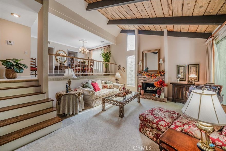 Welcome to this spacious tri-level, light-filled “End Unit” townhome, beautifully located within the highly sought-after Studio Village complex with a large greenbelt pool and spa very near the unit. A gated and walled, private brick garden patio serves as the entrance to a split-level floor plan, opening to a living room with soaring cathedral-beamed ceilings, a floor-to-ceiling south-facing window featuring gorgeous frosted stained-glass insets, a natural brick fireplace and hearth, and sliding doors leading to the private patio for BBQing and entertaining. The large dining area visible from the living room includes a wet bar with storage cabinets and connects to a bright galley kitchen featuring stainless steel appliances, custom tile countertops and backsplash, and a charming breakfast area connected to a family room/den (possible 3rd bedroom) with the addition of a wall, and an adjacent 3/4 guest bath and storage closet. Upstairs, two generously sized en-suite bedrooms feature large, screened picture windows, bathrooms, and walk-in closets. The primary bedroom features a fantastic window seat and an extra-large walk-in closet. A private direct-access two-car garage has two walls of built-in storage cabinets and a laundry area. The HOA includes earthquake insurance, on-site management, security patrol, landscape maintenance, cable TV/internet, water, and access to incredible amenities, including six heated pools, five spas, tennis & pickleball courts, and more. Located in the coveted Carpenter Community Charter School district and near Tujunga Village, Woodbridge Park, Ventura Blvds trendy shops, cafes, and the Sunday Farmers Market, this townhome truly is a rare find in a fantastic community.