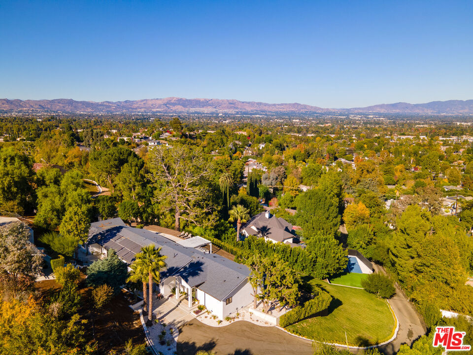Welcome to a world of elegance, privacy, and breathtaking views! This property redefines exclusivity, featuring a pool house, a separate guest house with its own private entrance, and a sprawling compound nestled on nearly 1.5 acres. As you enter through the gated driveway, you're greeted by a sanctuary of sophistication and comfort.The 5,400 sq.ft. main house boasts 5 bedrooms and 5.5 bathrooms, where high ceilings, recessed lighting, and engineered flooring create an ambiance of refined luxury. Four en suite bedrooms with custom closets ensure comfort for all, while the expansive kitchen is a chef's dream complete with a center island, marble countertops, and top-tier Viking appliances, all framed by captivating views.The primary suite is your personal retreat, offering backyard access, serene vistas, and a spa-like bathroom with high-end finishes. Step into the entertainer's paradisea 200-foot deck overlooking panoramic views, an outdoor kitchen, bar, fire pit, and a sparkling pool with a dedicated pool house.This estate is designed for modern living, equipped with a 3-car garage, 3-zone HVAC, security cameras, tankless water heaters, and paid solar panels. Active lifestyles will thrive on the half-court basketball area, 3-hole putting green, and expansive grounds that invite endless possibilities.The charming 1+1 guest house offers a private gated entrance on Citrus Ridge Dr., high-pitched beam ceilings, an open kitchen, built-in surround sound, and stunning views, making it perfect for guests, a rental, or a workspace.With space for a vegetable garden and RV access, this property combines luxurious living with practicality. Don't miss your opportunity to own this extraordinary blend of elegance, privacy, and serene living.